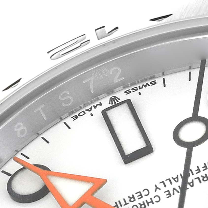 The image shows a close-up view of the dial and bezel of a Rolex Explorer 226570 Men
s Stainless Steel White Dial 226570 Men
s Stainless Steel White Dial watch, highlighting the orange hand and some hour markers.