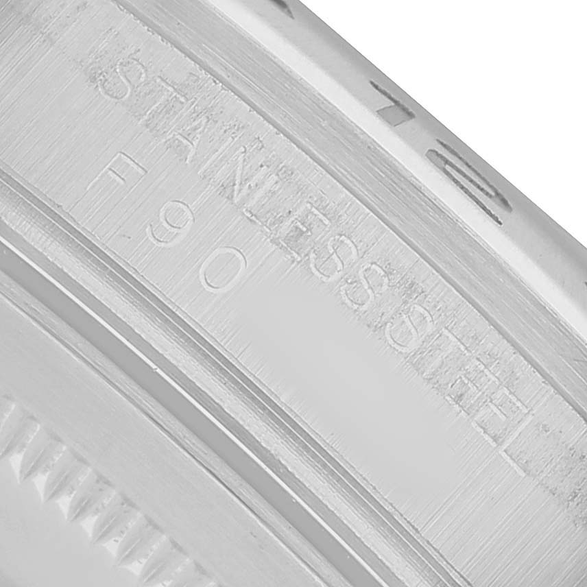 The image shows a close-up of the Rolex Explorer 16570 Men's Stainless Steel Black Dial's stainless steel watch casing, highlighting engraved text.