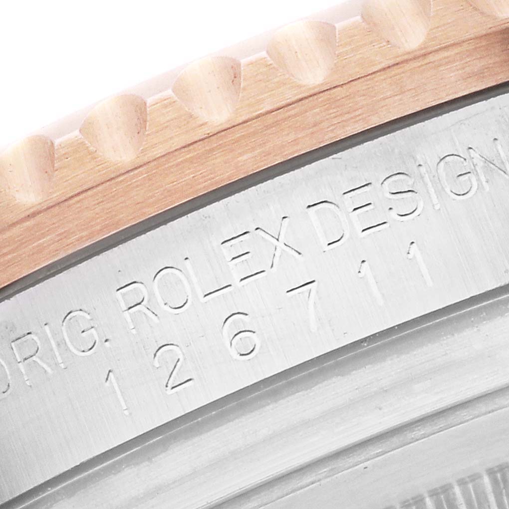 This close-up image shows the edge and engraved serial number of the Rolex GMT-Master 126711CHNR Men's Steel and Gold (two tone) Black Dial 126711CHNR Men's Steel and Gold (two tone) Black Dial watch bezel.