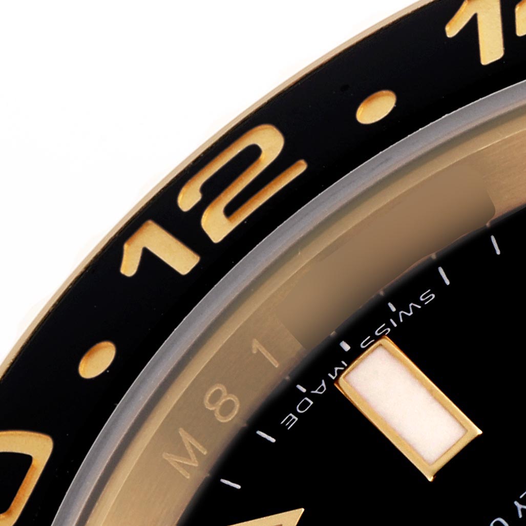 The close-up image shows part of the bezel and dial of a Rolex GMT-Master 116718 Men
s Yellow Gold Black Dial 116718 Men
s Yellow Gold Black Dial, focusing on the 12 o
clock position and numeral details.