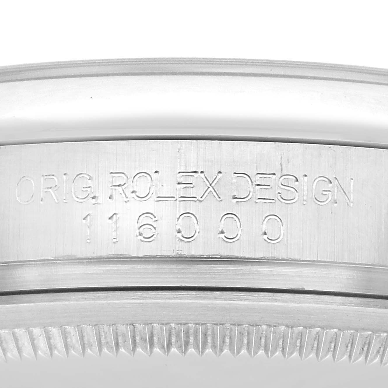 The image shows a close-up of the engraved side of a Rolex Oyster Perpetual 116000 Men's Stainless Steel Silver Dial 116000 Men's Stainless Steel Silver Dial bezel with model number 116000.