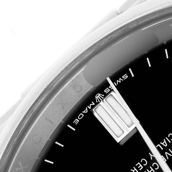 The image shows a close-up of the dial and edge of the bezel of a Rolex Oyster Perpetual 126000 Men's Stainless Steel Black Dial, highlighting the "Swiss Made" label.