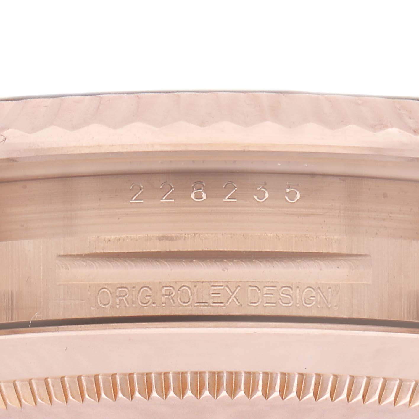 The image shows the side view of a Rolex President 228235 Men's Rose Gold Brown Dial model, highlighting its bezel and engraved details.
