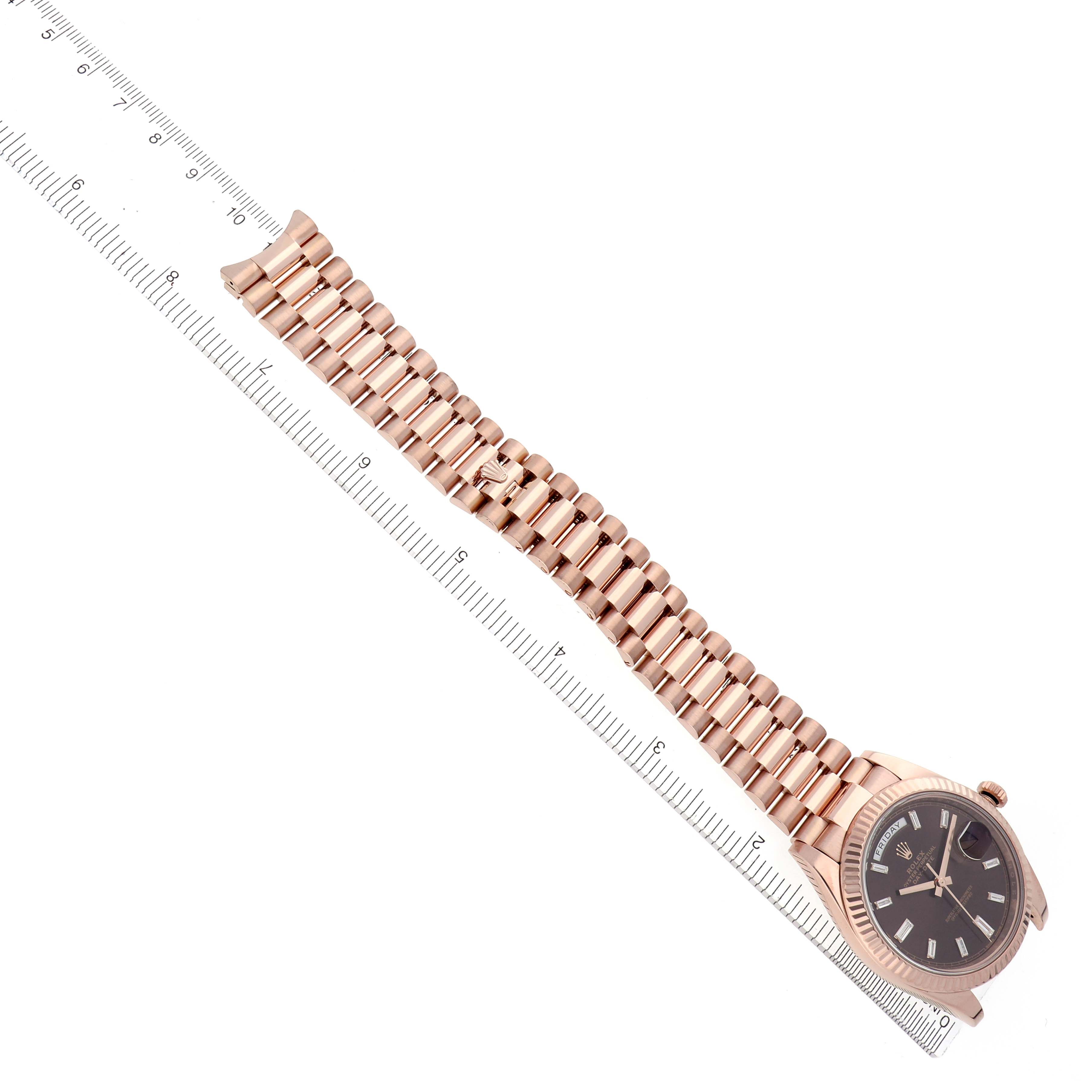 The Rolex President 228235 Men
s Rose Gold Brown Dial 228235 Men
s Rose Gold Brown Dial model watch is shown at an angle displaying part of the band alongside a ruler for size reference.