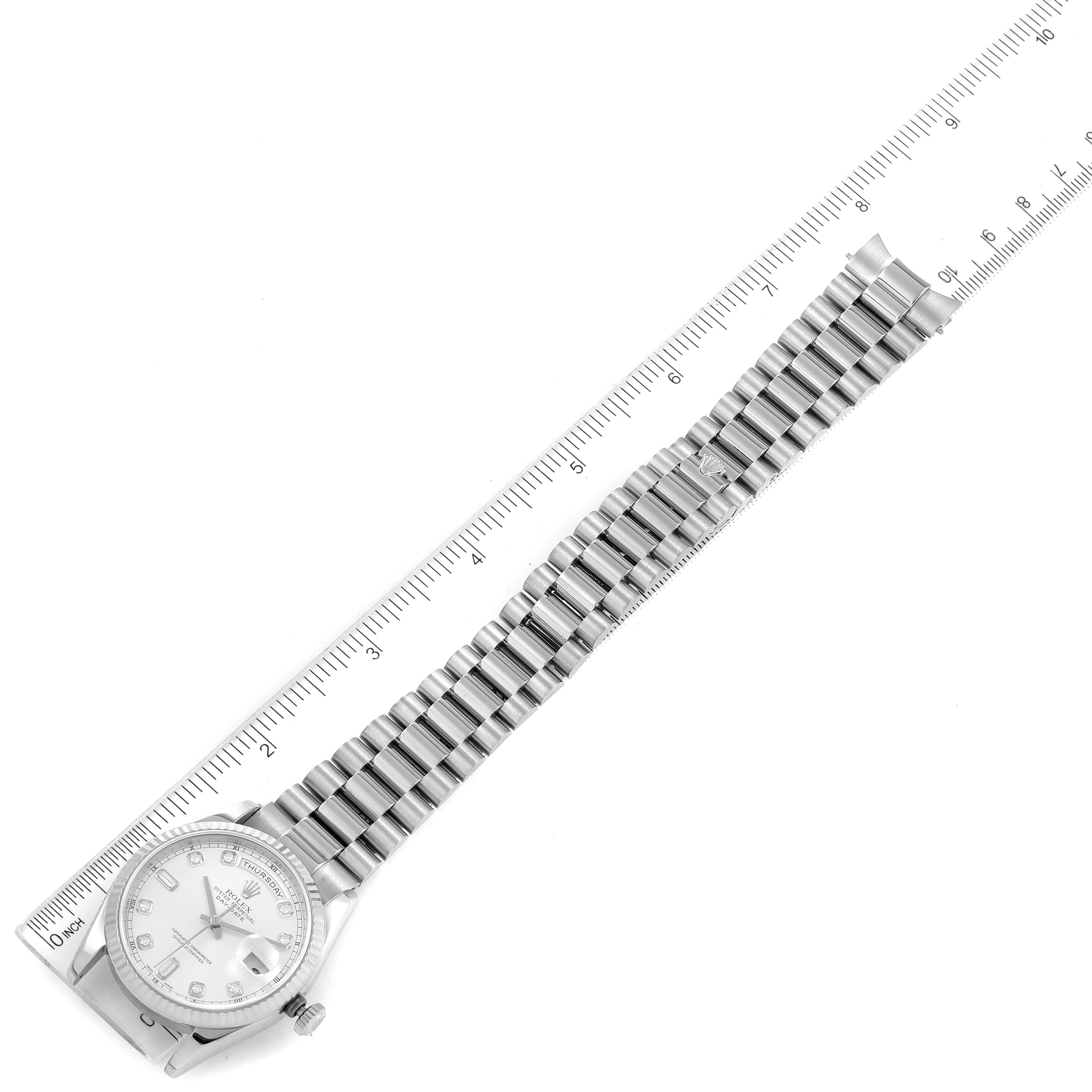The Rolex President 118239 Men
s White Gold Silver Dial 118239 Men
s White Gold Silver Dial model watch is shown from a top-down angle with its entire bracelet and a ruler for measurement comparison.