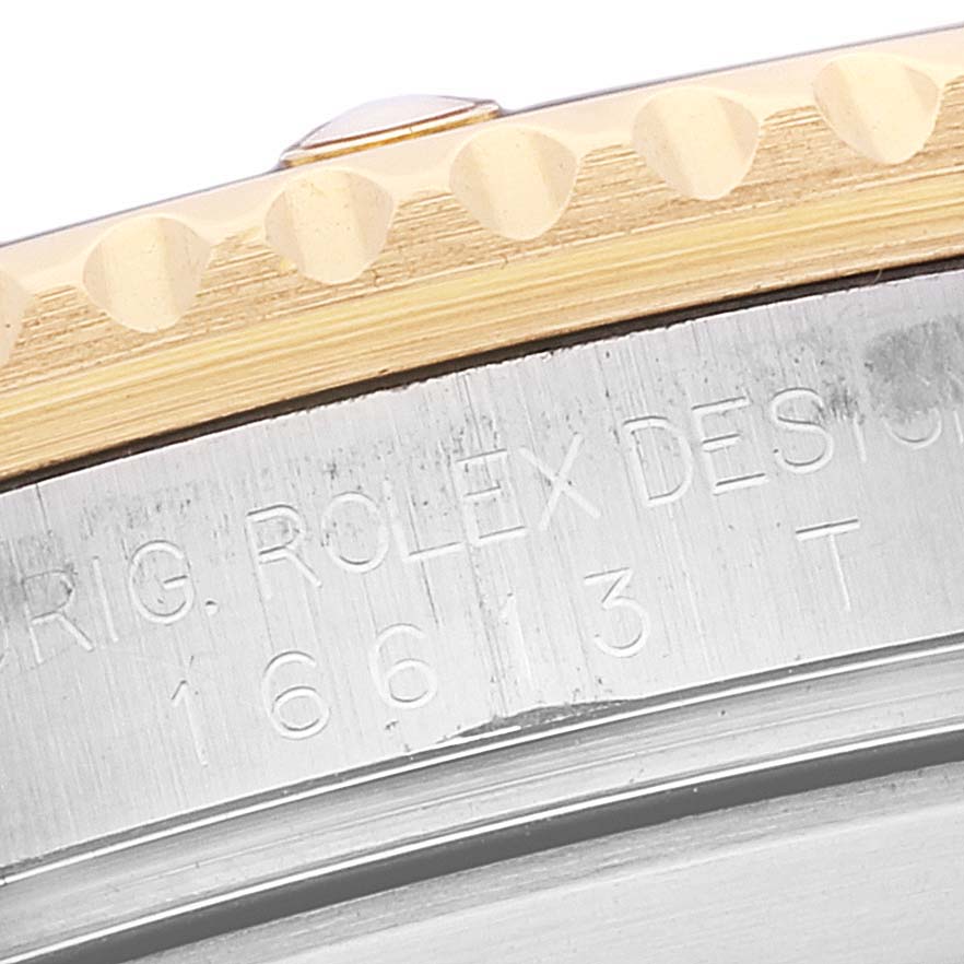 The image shows an angled close-up of the side of a Rolex Submariner 16613 Men's Steel and Gold (two tone) Blue Dial 16613 Men's Steel and Gold (two tone) Blue Dial watch case, displaying part of the bezel with engravings.