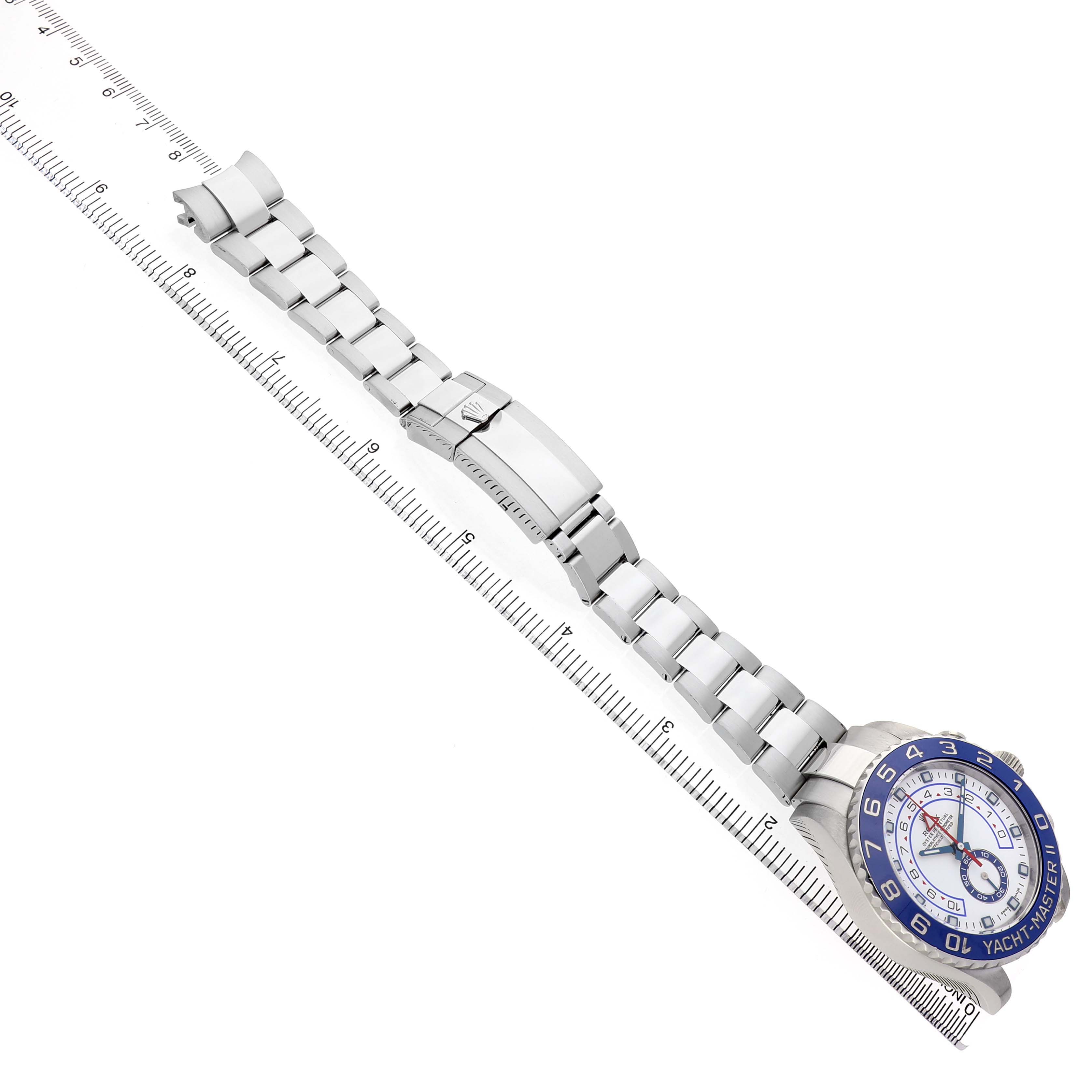 The image shows a top-down view of the Rolex Yacht-Master 116680 Men's Stainless Steel White Dial watch, highlighting its bracelet, clasp, and face alongside a ruler.