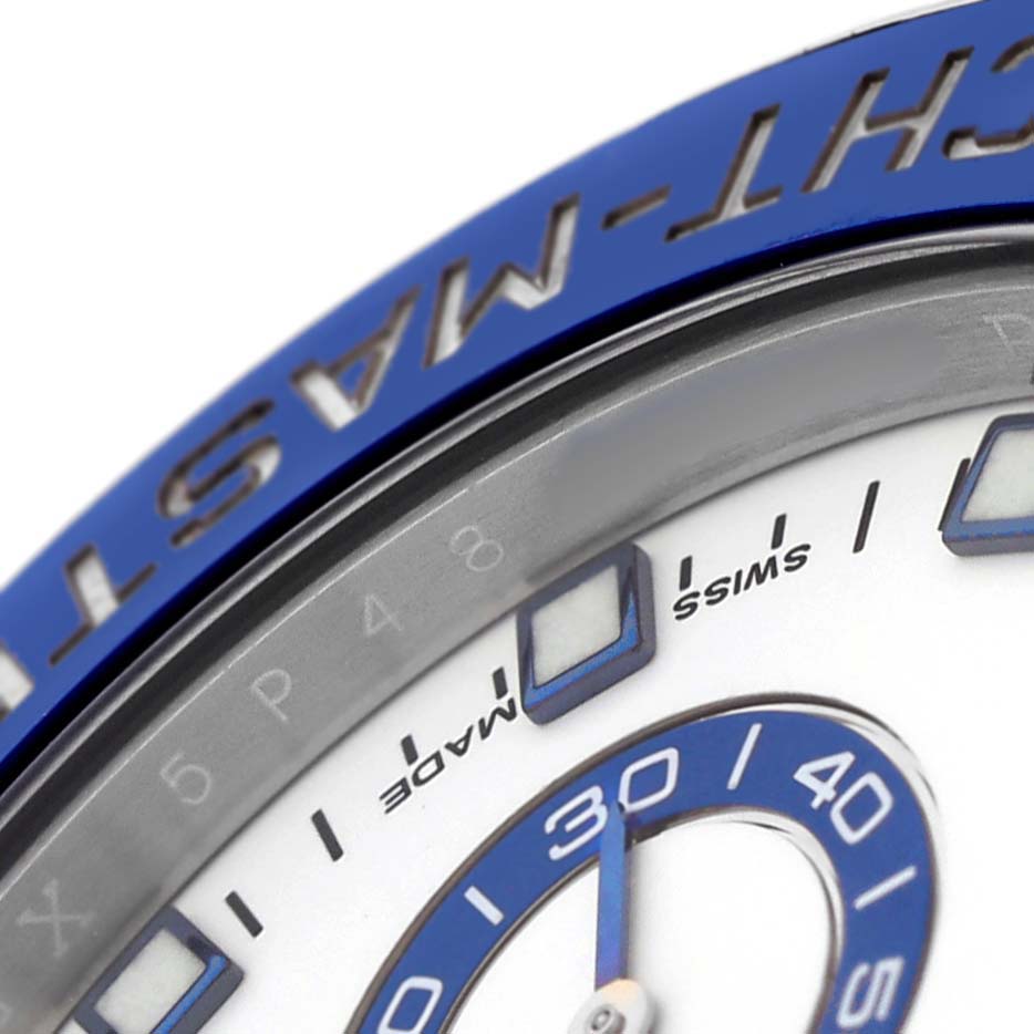 The image shows a close-up of the Rolex Yacht-Master 116680 Men's Stainless Steel White Dial's blue bezel, partial dial, and hands.