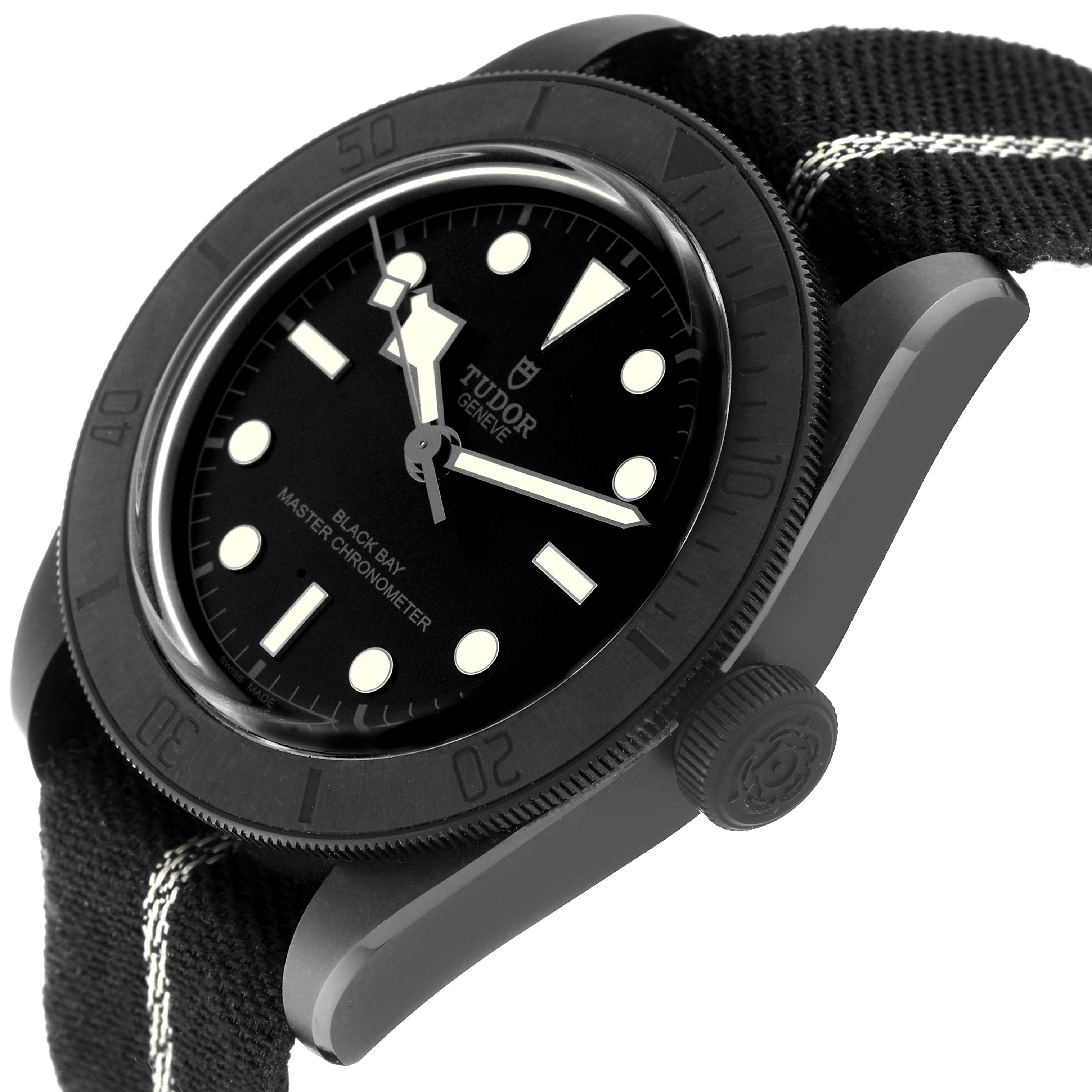 The image shows a tilted side view of the Tudor Heritage Black Bay 79210CNU Men's Ceramic Black Dial 79210CNU Men's Ceramic Black Dial watch, highlighting the dial, bezel, and fabric strap.