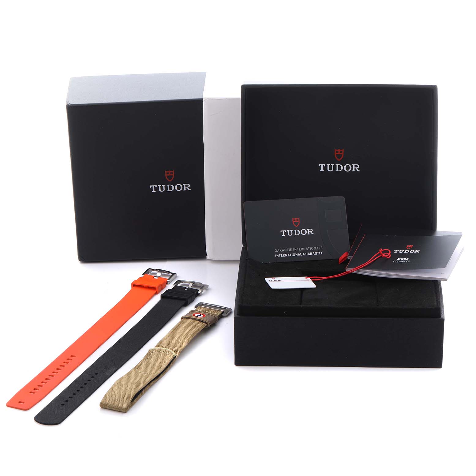 The image shows Tudor Pelagos 2542G247NU-0001 Men
s Titanium Black Dial 2542G247NU-0001 Men
s Titanium Black Dial watch accessories, including multiple straps and packaging, viewed from a top angle.