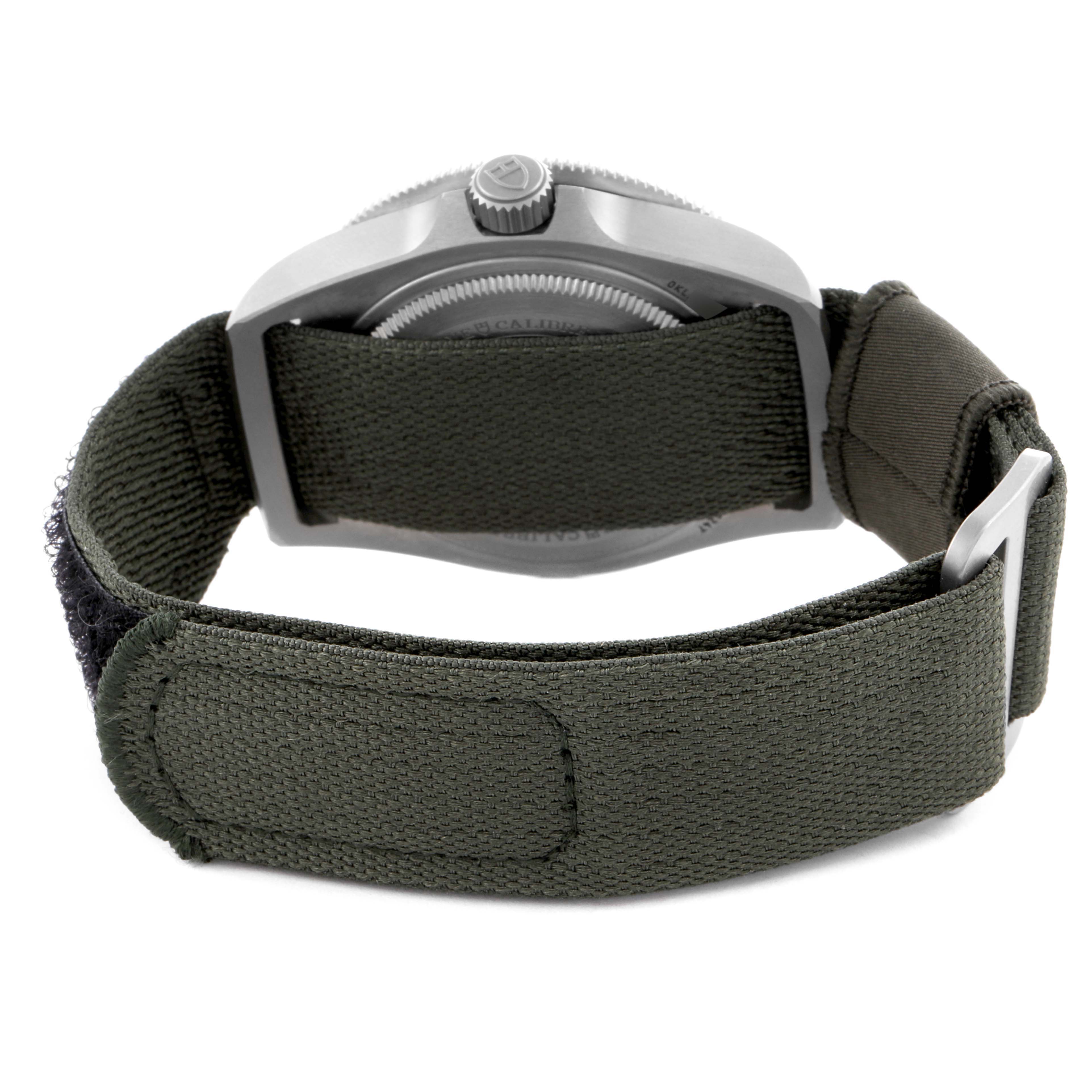 The image shows the back view of a Tudor Pelagos 2542G247NU-0001 Men
s Titanium Black Dial 2542G247NU-0001 Men
s Titanium Black Dial watch with a green fabric strap and visible buckle.