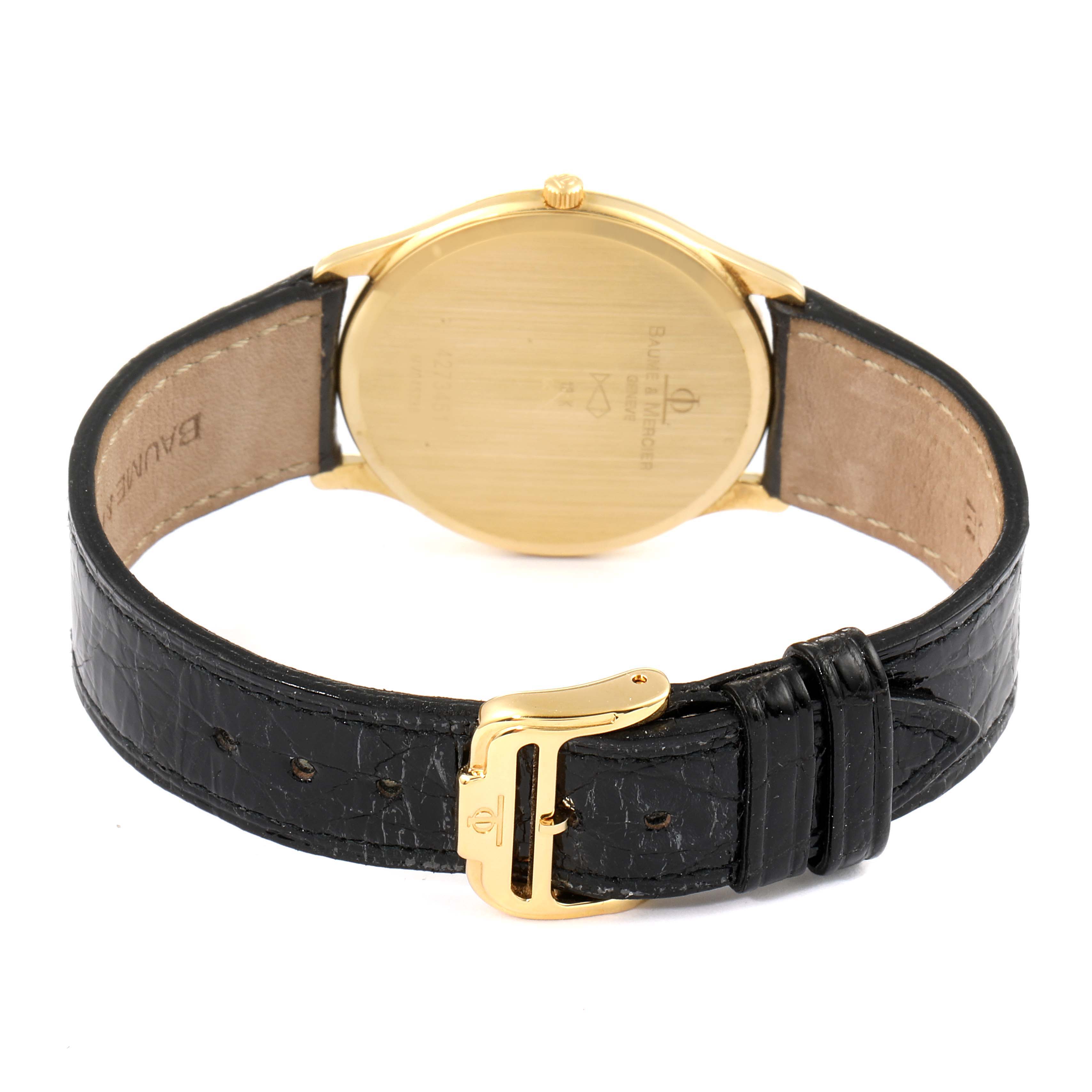 The image shows the back case and strap of a Baume & Mercier Classima MV045236 Men's Yellow Gold White Dial MV045236 Men's Yellow Gold White Dial watch, highlighting the gold case and black leather strap with a gold buckle.