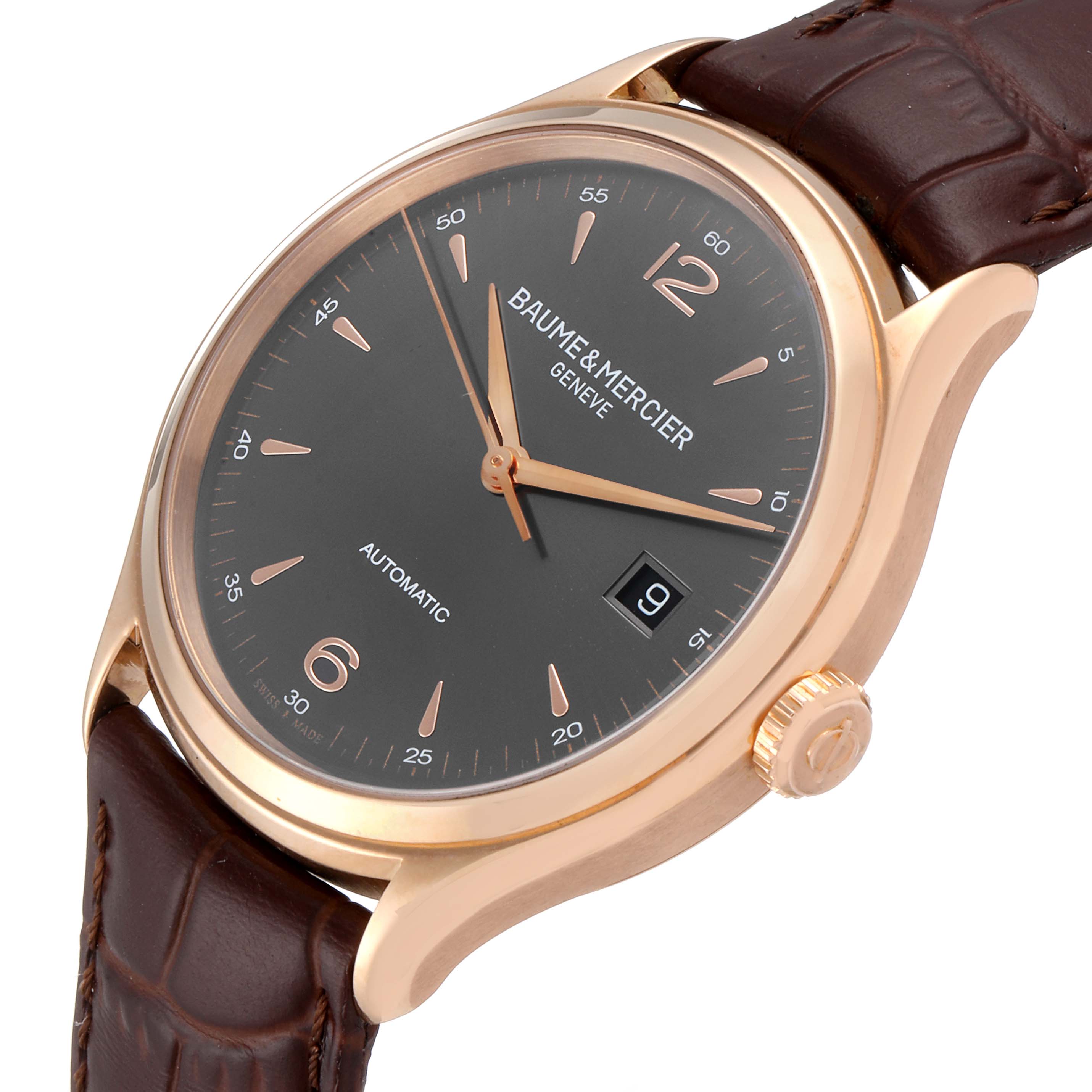 The image shows a close-up of a Baume & Mercier Clifton M0A10059 Men's Rose Gold Grey Dial M0A10059 Men's Rose Gold Grey Dial watch, highlighting the dial, crown, and part of the leather strap.