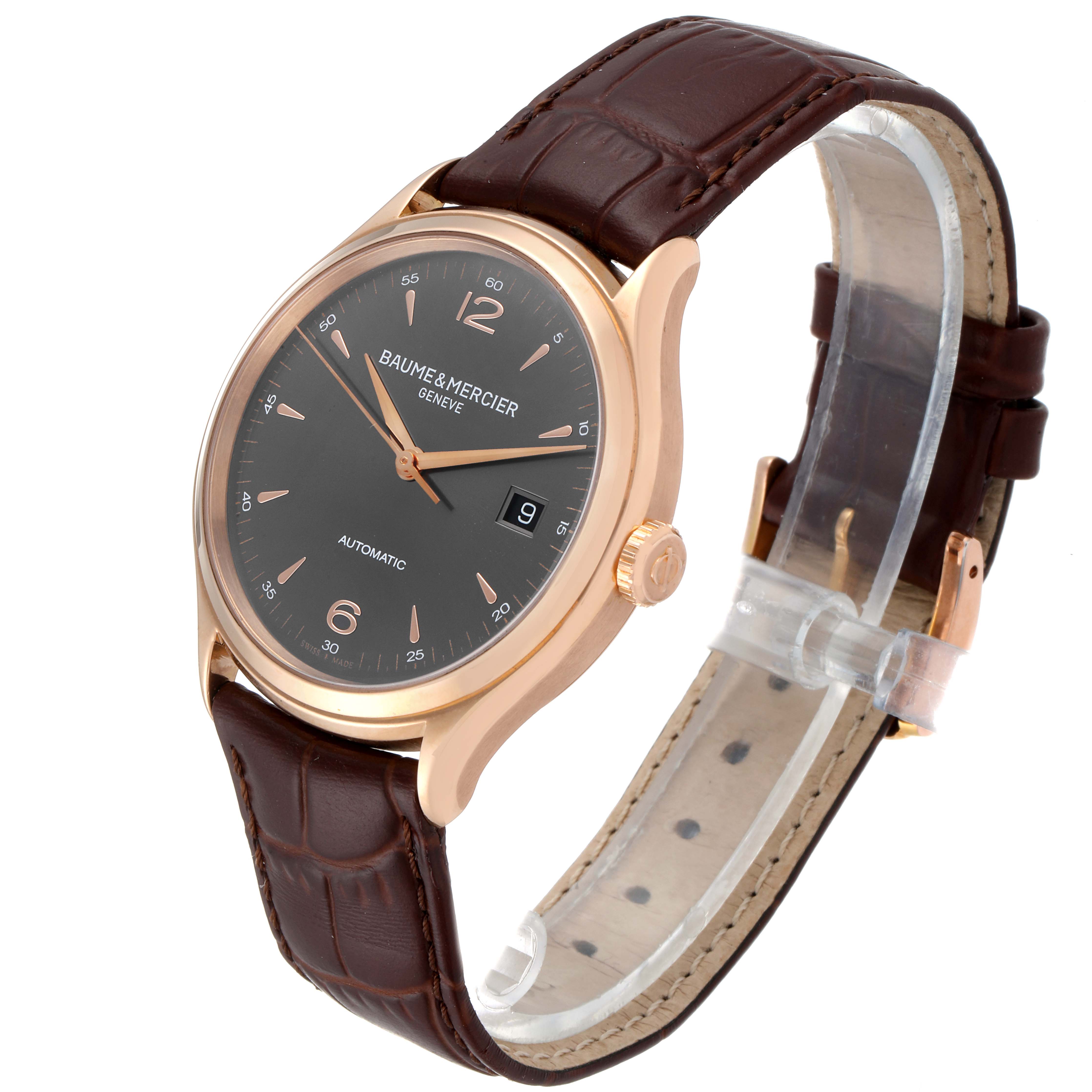 The image shows a Baume & Mercier Clifton M0A10059 Men's Rose Gold Grey Dial M0A10059 Men's Rose Gold Grey Dial watch at an angle, highlighting its face, crown, and brown leather strap.