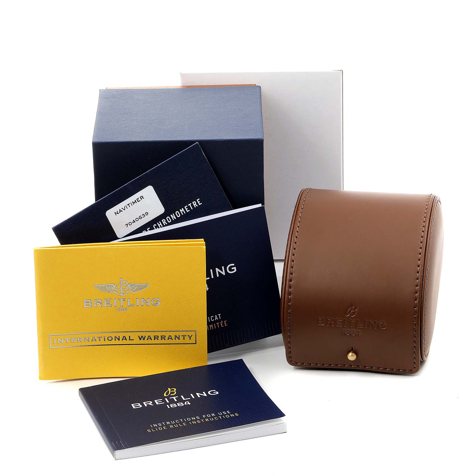 The Navitimer by Breitling is shown with its box, warranty card, manuals, and a brown leather case.