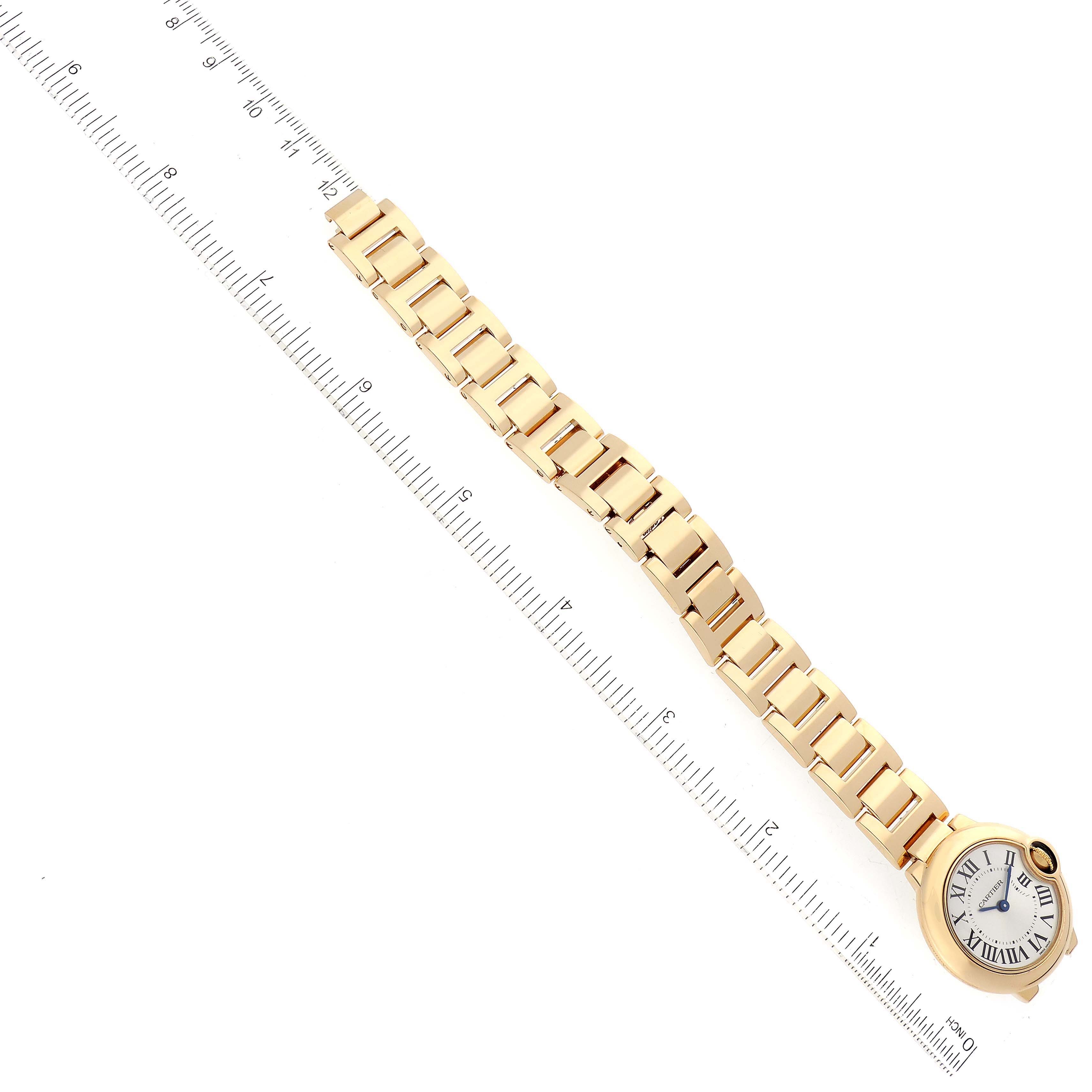 This image shows a Ballon Bleu de Cartier watch laid out flat beside a measuring ruler.