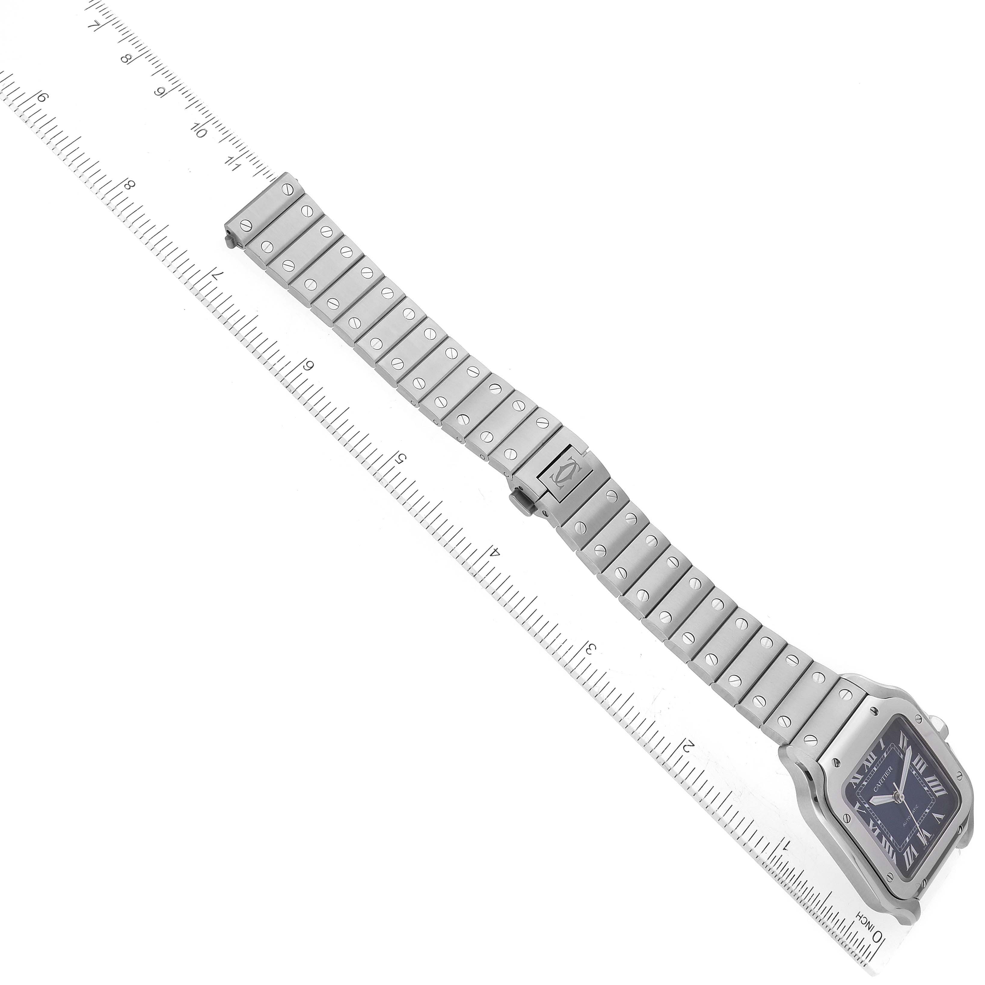 The image shows the Santos model watch by Cartier laid out flat with band fully extended next to a ruler for measurement.