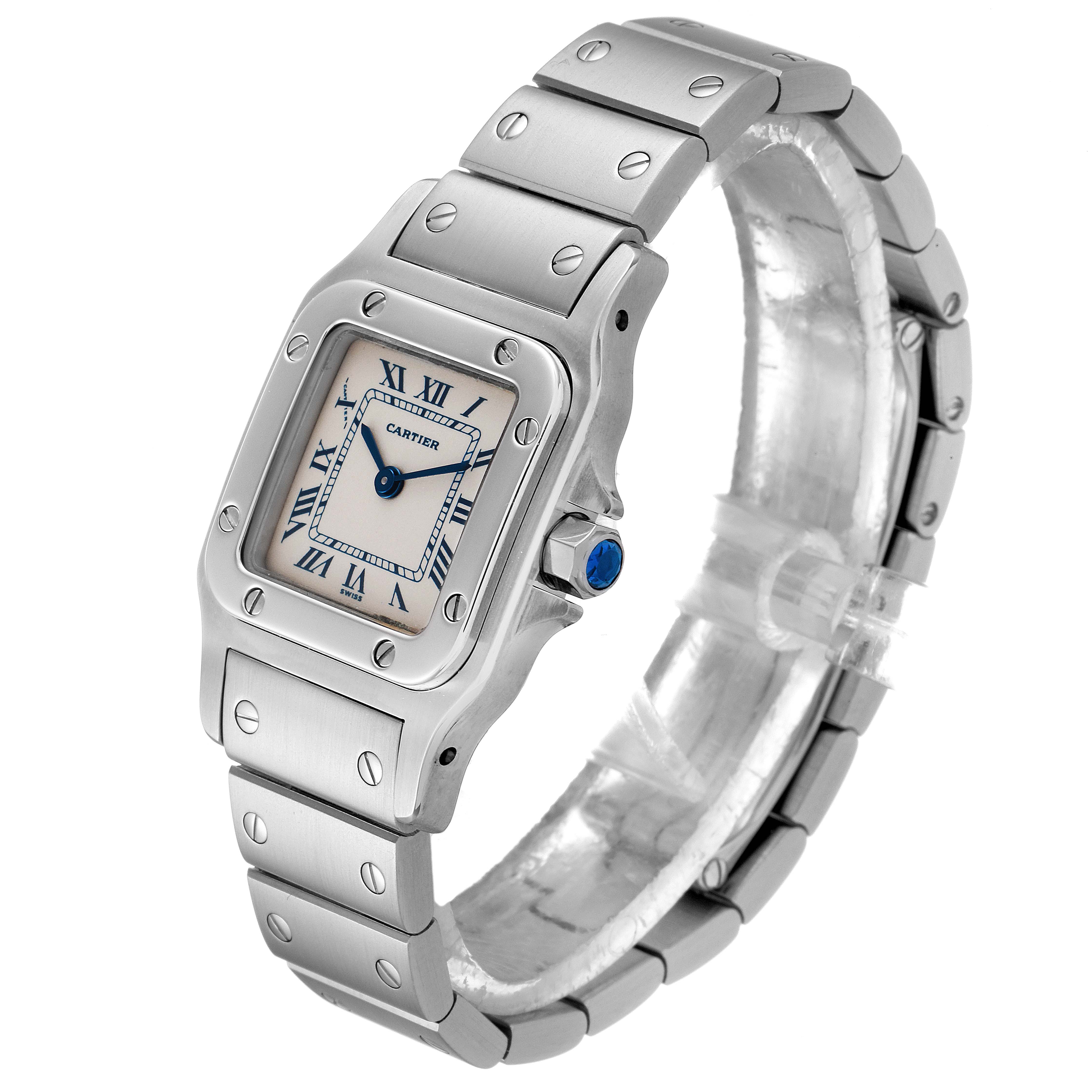The image shows a side-angle view of the Santos by Cartier watch, highlighting the face, bezel, crown, and part of the bracelet.