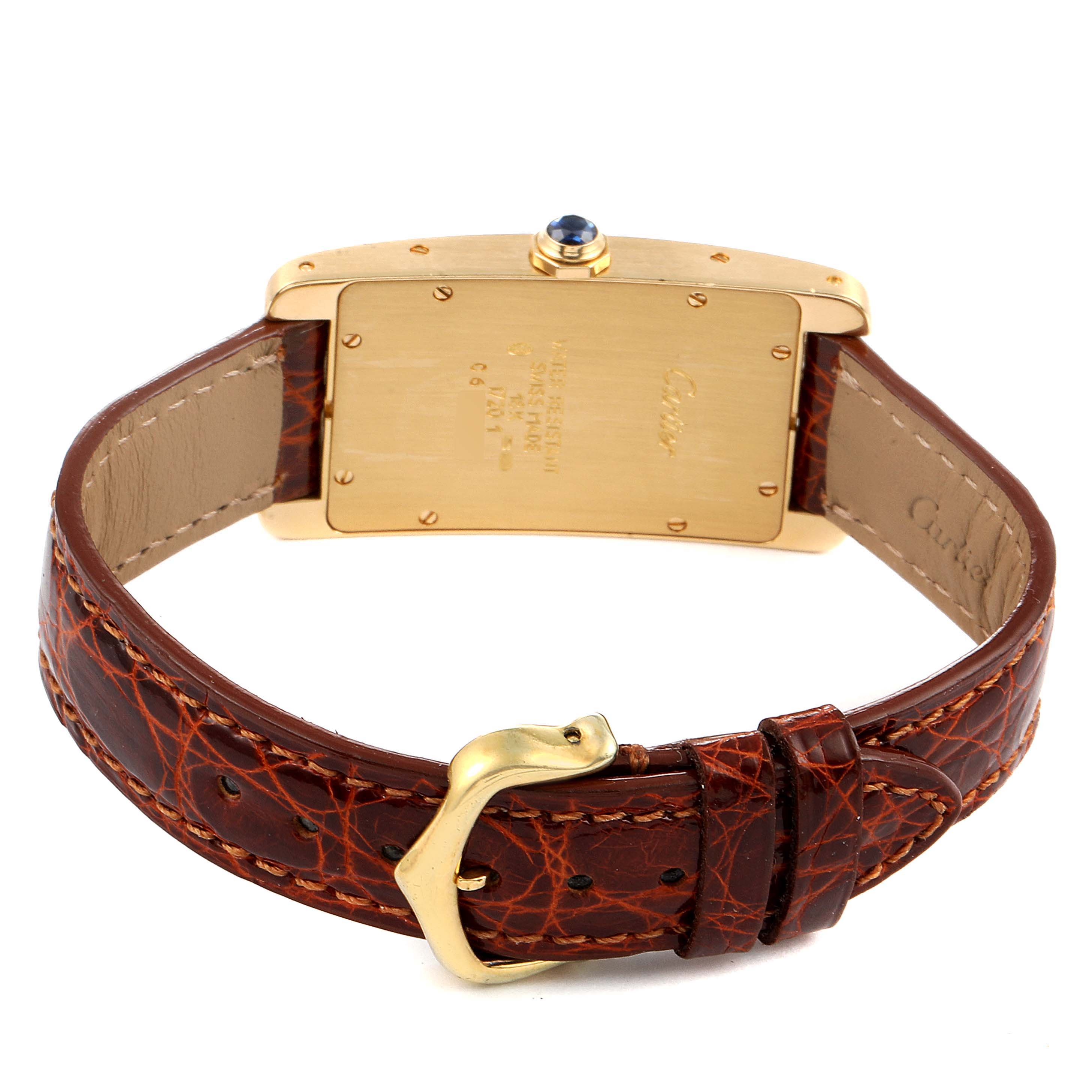 The image shows the back view of a Cartier Tank Americaine W2601456 Men's Yellow Gold Silver Dial W2601456 Men's Yellow Gold Silver Dial watch, highlighting its leather strap and gold buckle.