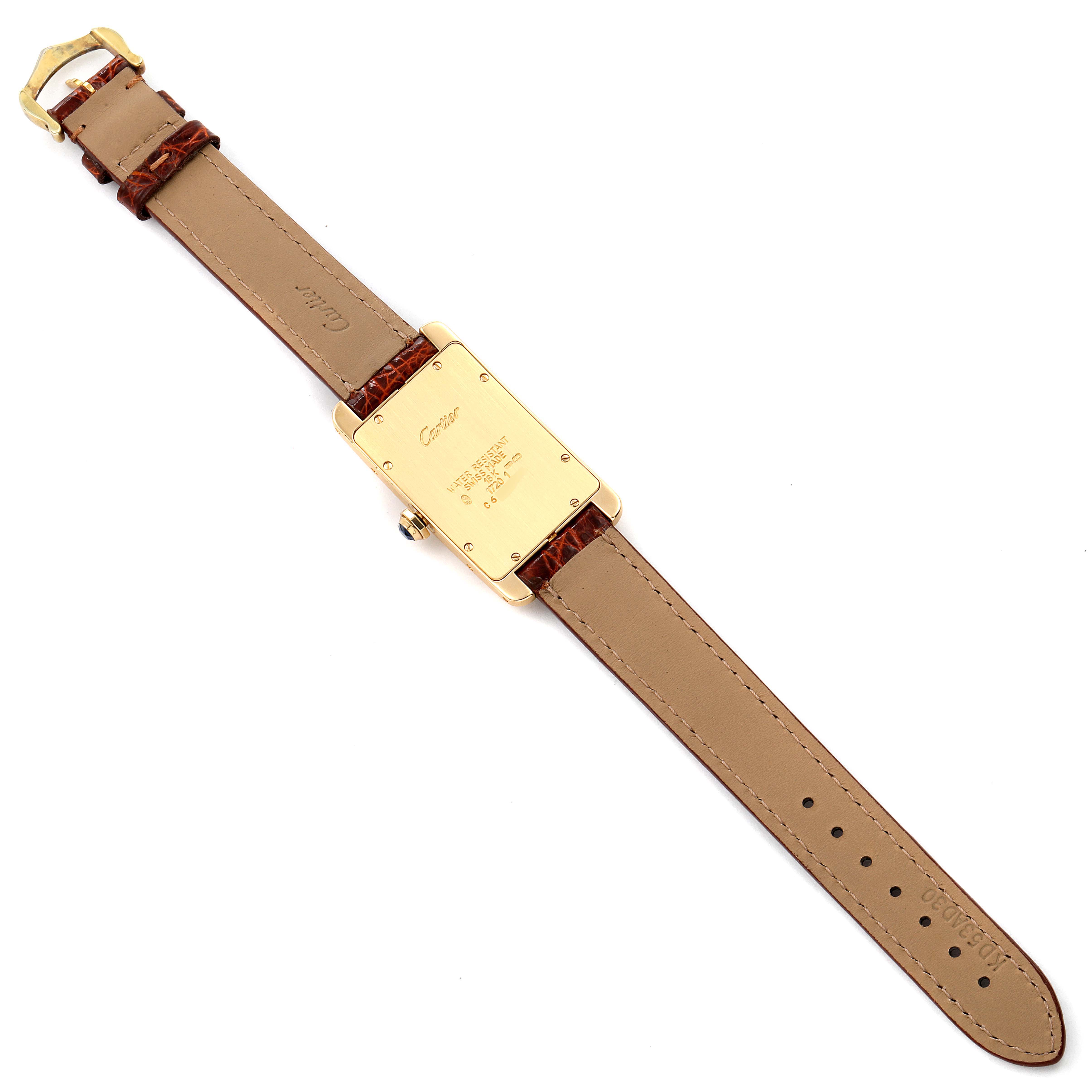 The image shows the back side of a Cartier Tank Americaine W2601456 Men's Yellow Gold Silver Dial W2601456 Men's Yellow Gold Silver Dial watch, displaying the case back and leather strap.