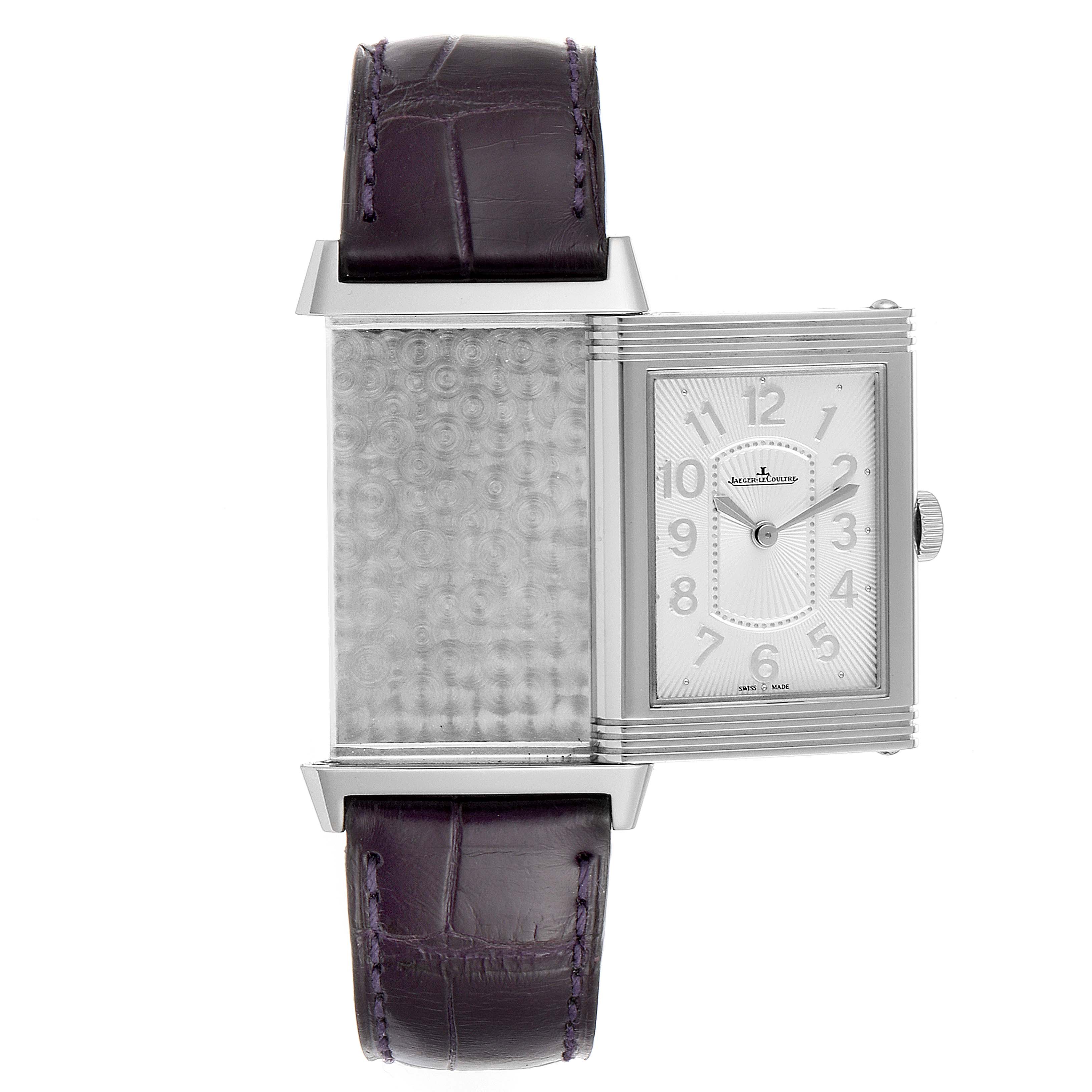 The Jaeger LeCoultre Reverso 268.8.47 Women's Stainless Steel Silver Dial 268.8.47 Women's Stainless Steel Silver Dial watch is shown partially flipped, revealing its back and front with a purple leather strap.