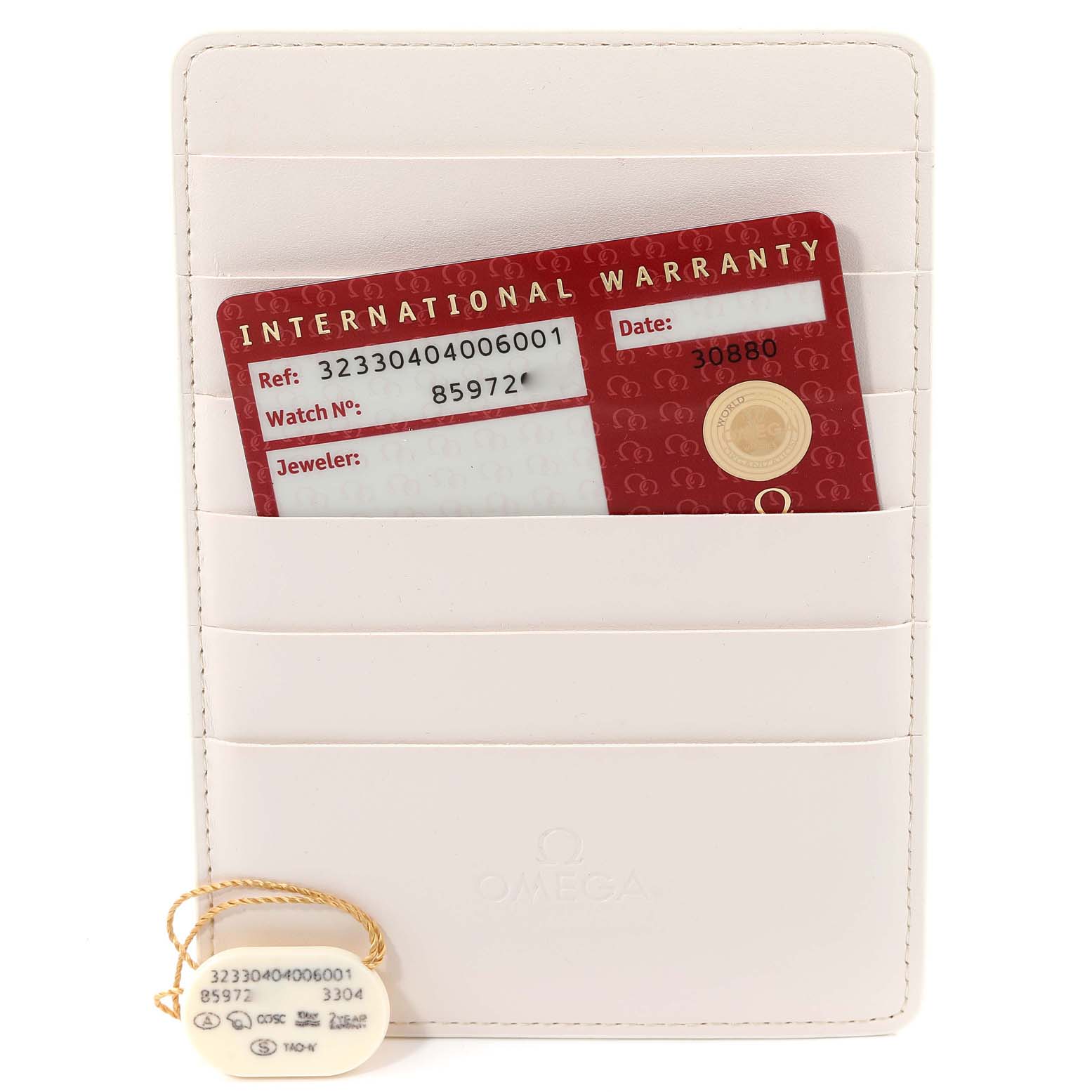 The image shows the warranty card and serial tag of an Omega Speedmaster 323.30.40.40.06.001 Men's Stainless Steel Grey Dial 323.30.40.40.06.001 Men's Stainless Steel Grey Dial watch, placed in a white cardholder.