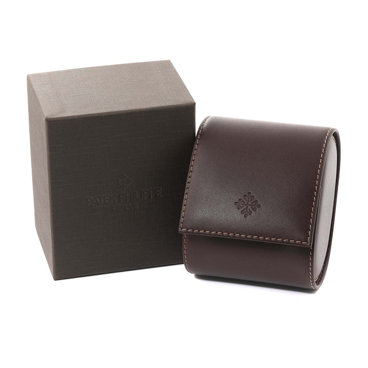 The image shows the packaging for a Patek Philippe Calatrava 5153R-001 Men's Rose Gold Silver Dial 5153R-001 Men's Rose Gold Silver Dial watch, including a brown leather travel case and a branded box.