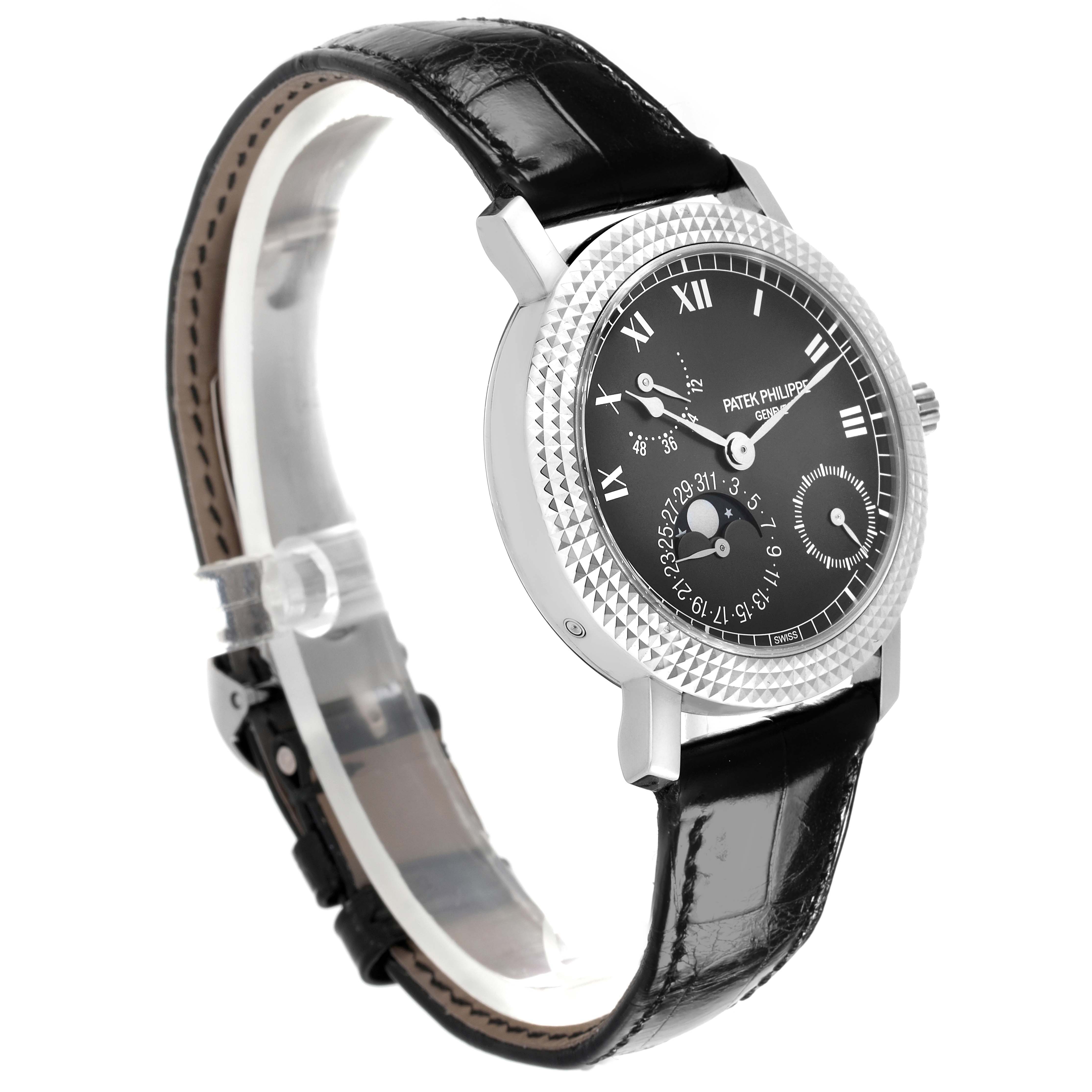 The Patek Philippe Calatrava 5057G-010 Men's White Gold Grey Dial watch is shown at a three-quarter angle, highlighting its textured bezel, black dial, and leather strap.
