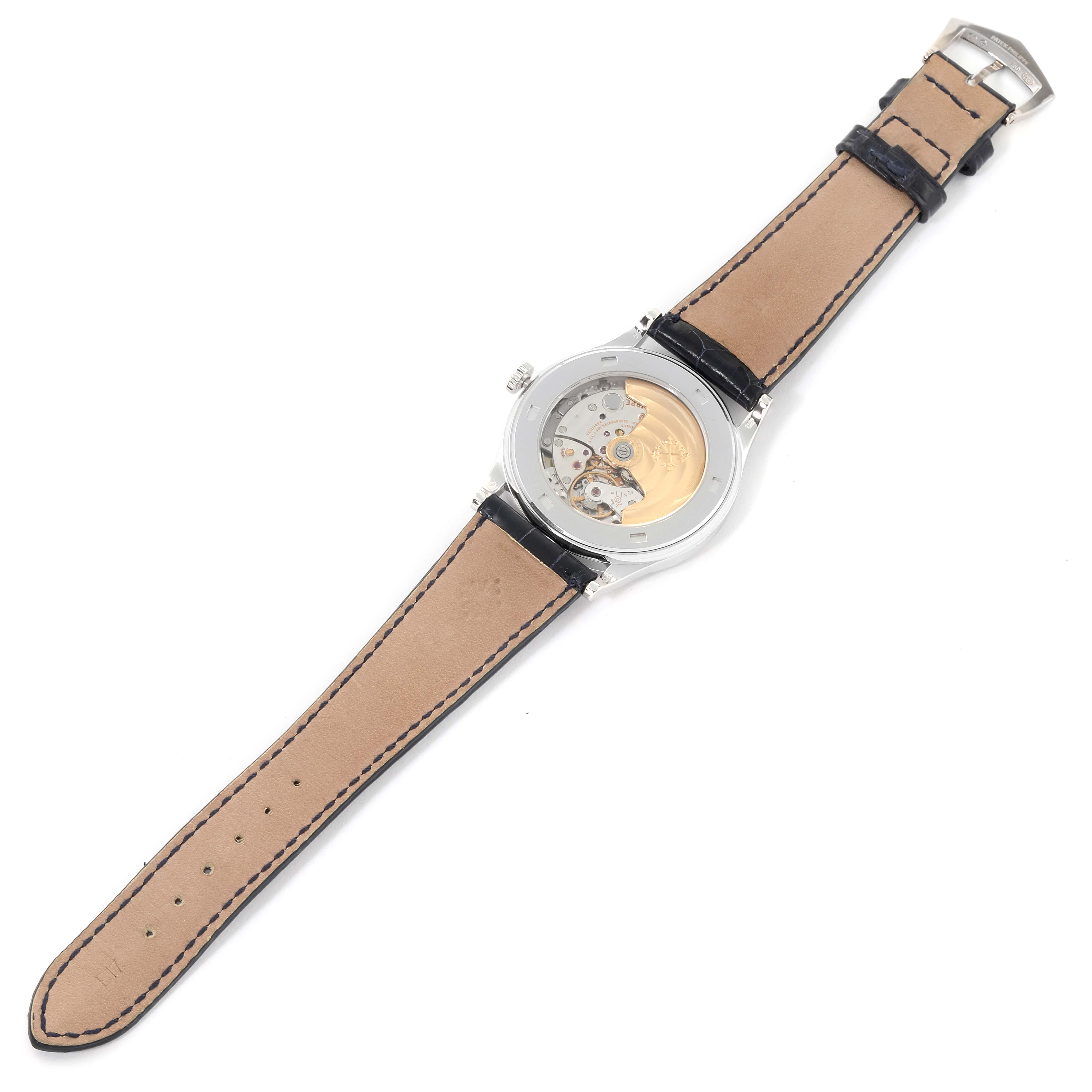 The image shows the back view of a Patek Philippe Calatrava 5296G Men
s White Gold Silver Dial 5296G Men
s White Gold Silver Dial watch with an exposed movement and a leather strap.