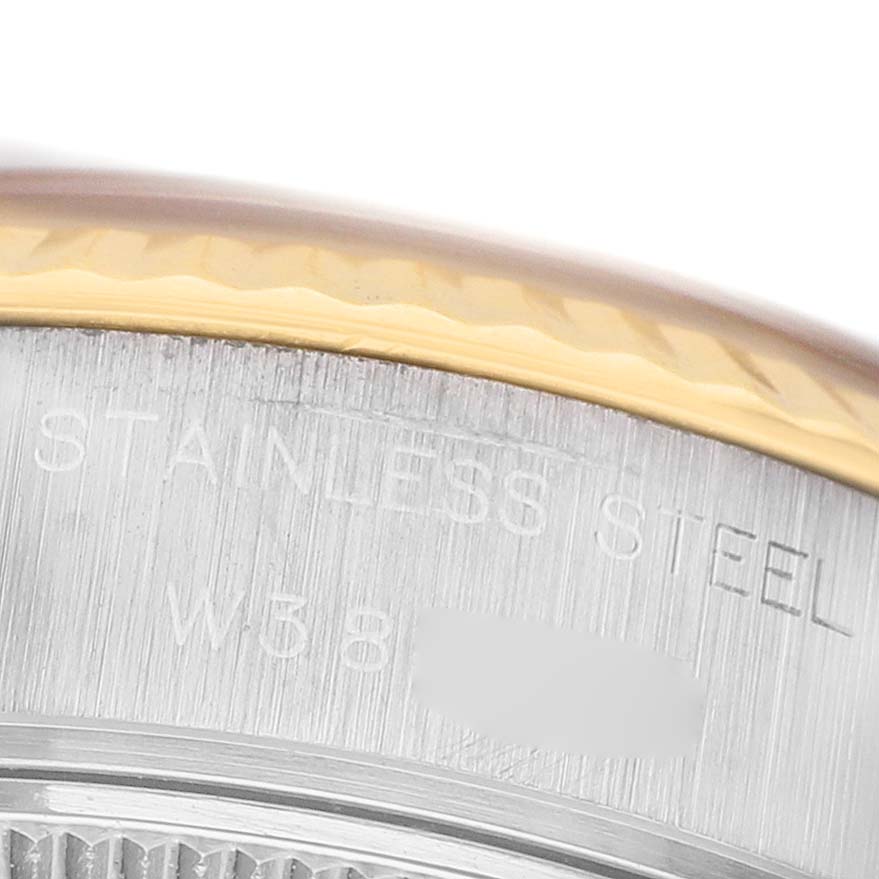 This close-up image of the Rolex Datejust 69173 Women's Steel and Gold (two tone) Champagne Dial watch shows the edge of the bezel and engraved text on the stainless steel casing.