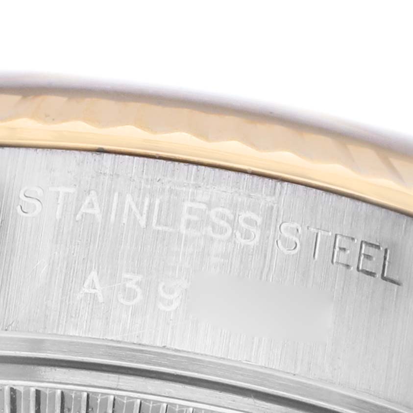 The image shows a close-up of the side of a Rolex Datejust 79173 Women's Steel and Gold (two tone) Champagne Dial, highlighting its stainless steel case and engraving details.