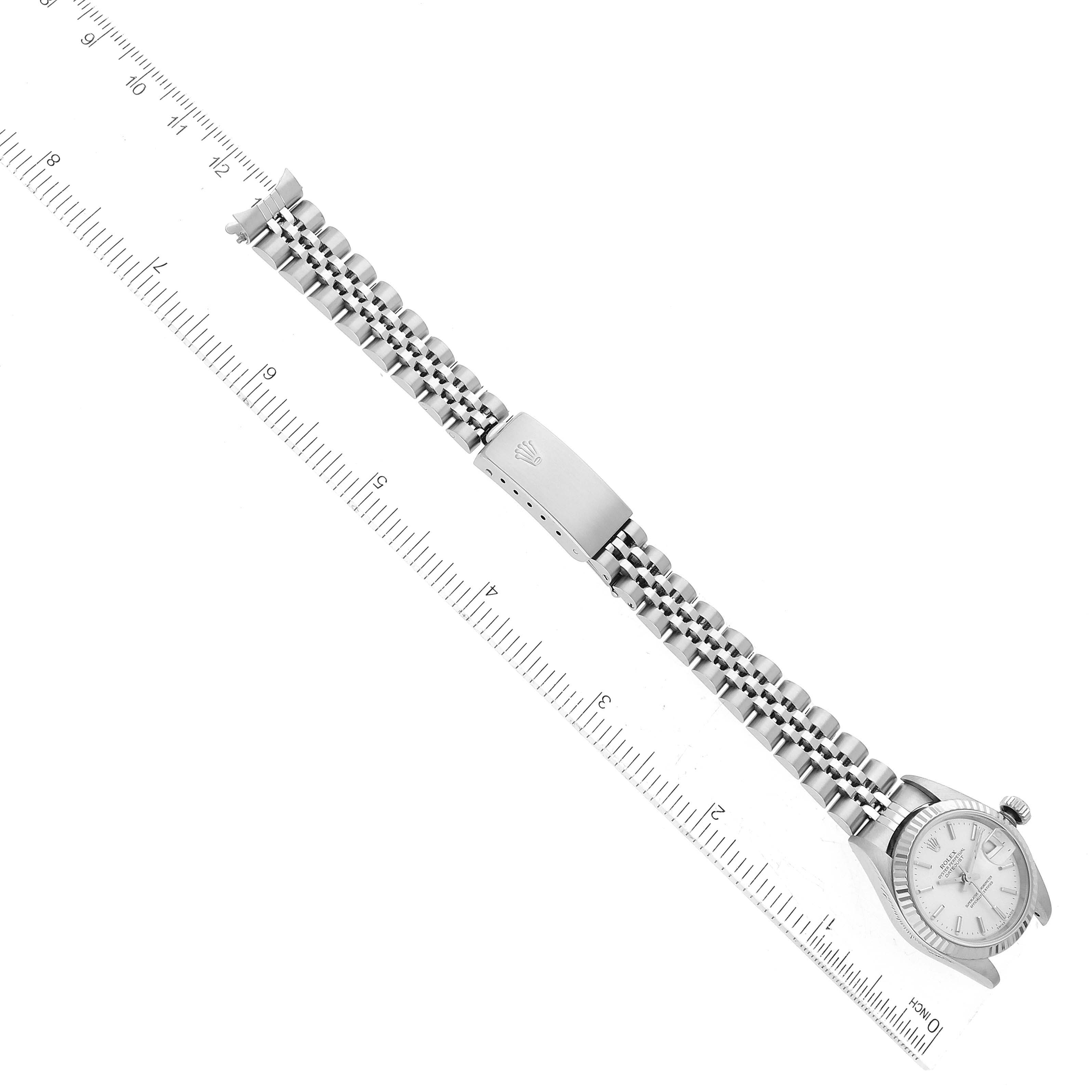 The image shows a top-down view of a Rolex Datejust 79174 Women's Stainless Steel Silver Dial 79174 Women's Stainless Steel Silver Dial watch with its face, bracelet, and clasp visible alongside a ruler.