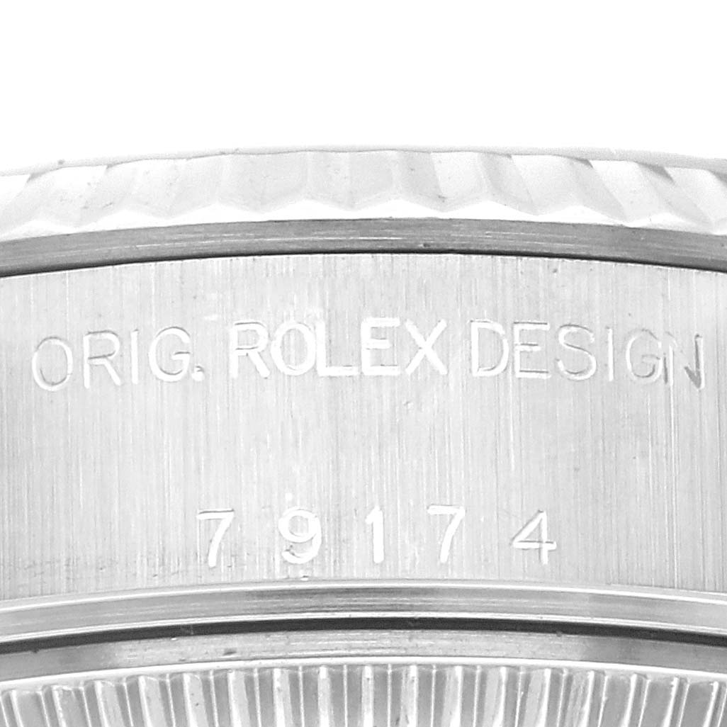 The image shows a close-up of the side of a Rolex Datejust 79174 Women's Stainless Steel Silver Dial 79174 Women's Stainless Steel Silver Dial watch, with "ORIG. ROLEX DESIGN 79174" engraved.