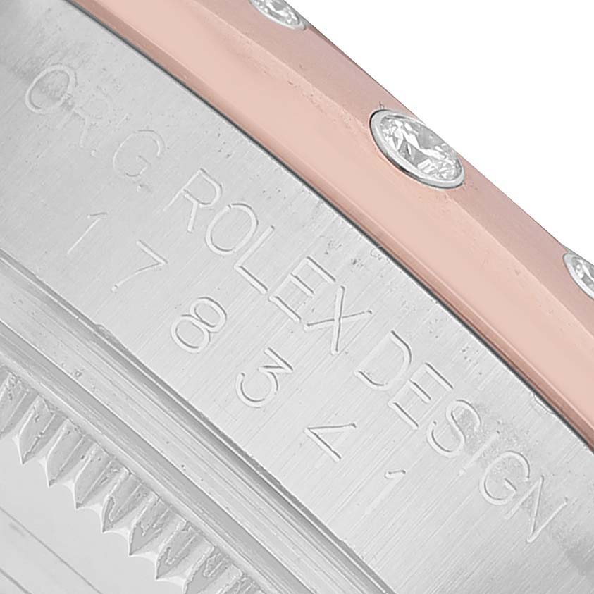 The image shows a close-up of the side of a Rolex Datejust 178341 Women's Steel and Gold (two tone) Brown Dial watch with engraved lettering and a diamond-studded bezel.