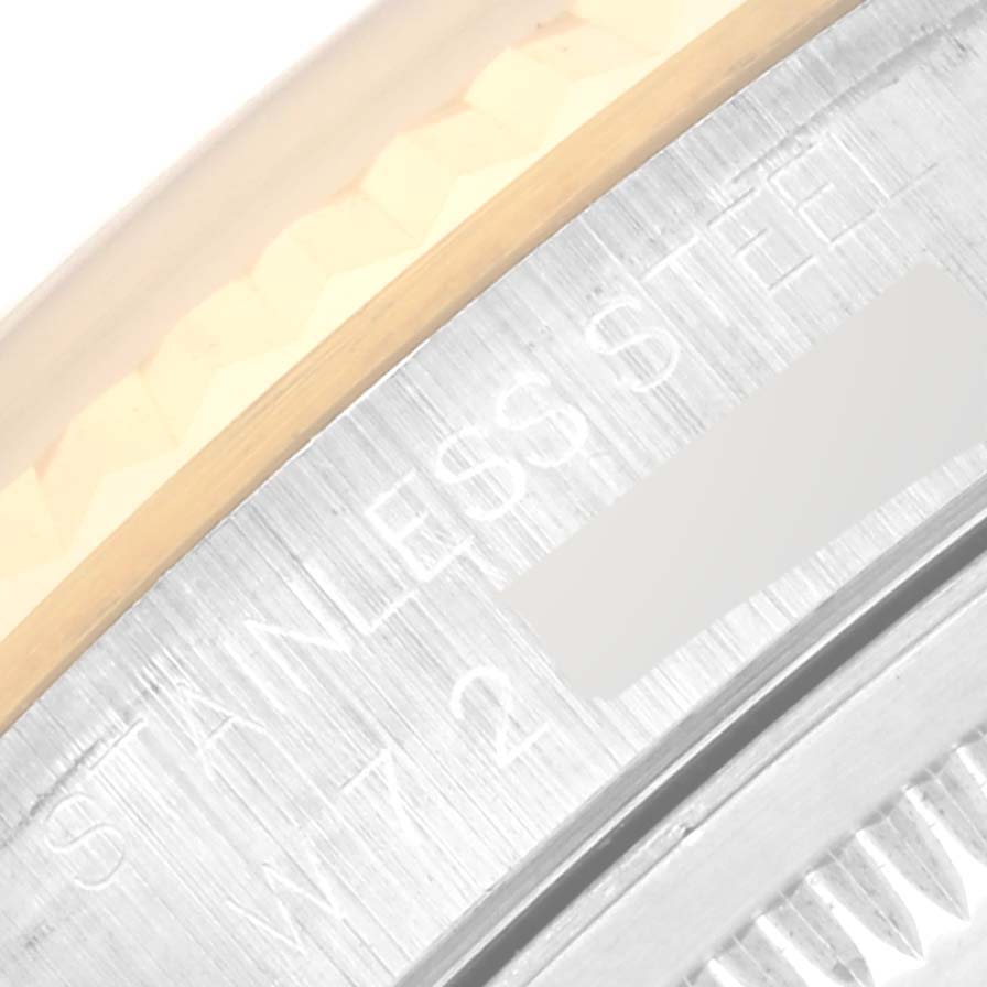 The image shows a close-up of the engraved text "STAINLESS STEEL" on the side of the bezel of a Rolex Datejust 16233 Men's Steel and Gold (two tone) Champagne Dial 16233 Men's Steel and Gold (two tone) Champagne Dial watch.