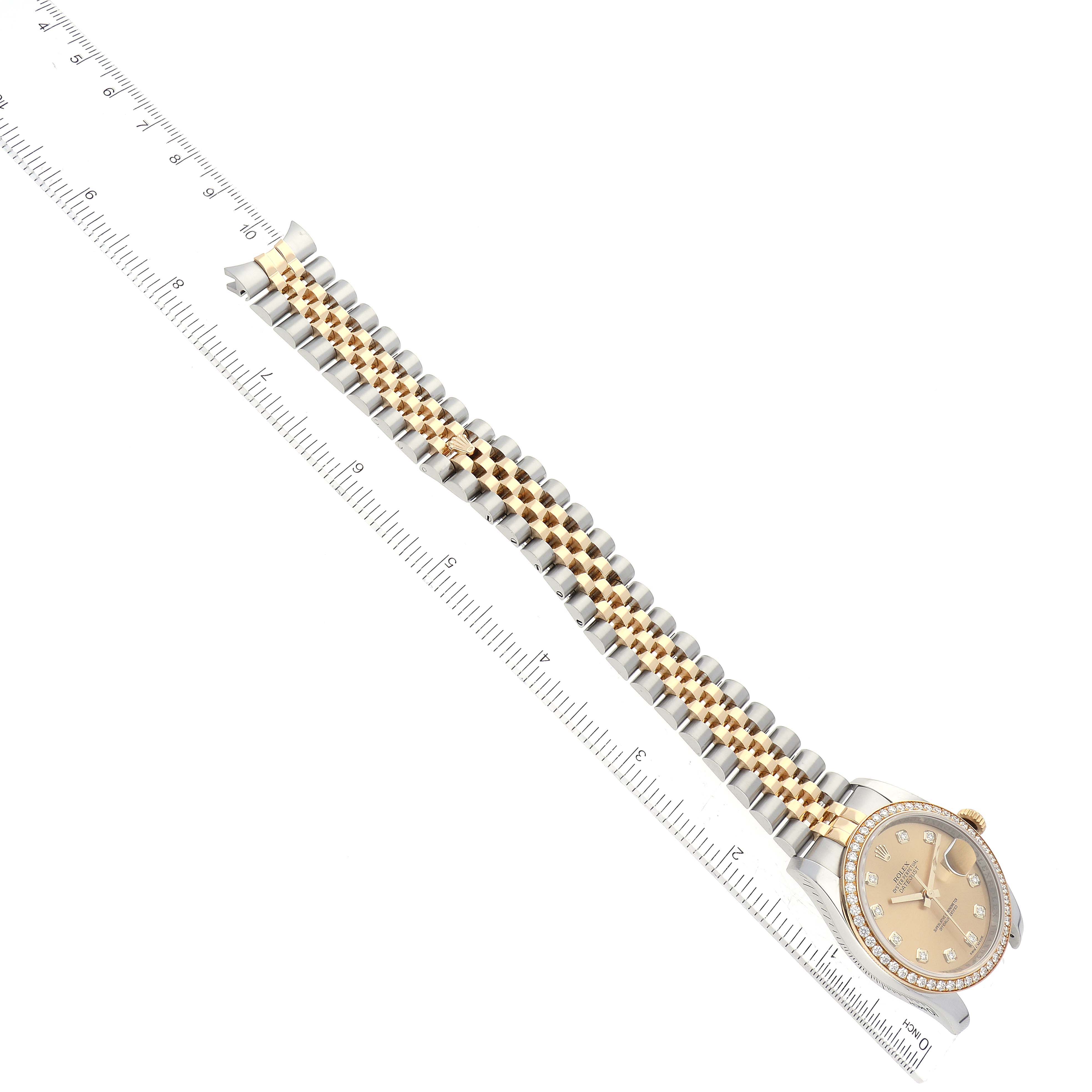 This image shows a Rolex Datejust 116243 Men's Steel and Gold (two tone) Champagne Dial 116243 Men's Steel and Gold (two tone) Champagne Dial watch lying flat, with the face and full-length bracelet visible alongside a ruler.