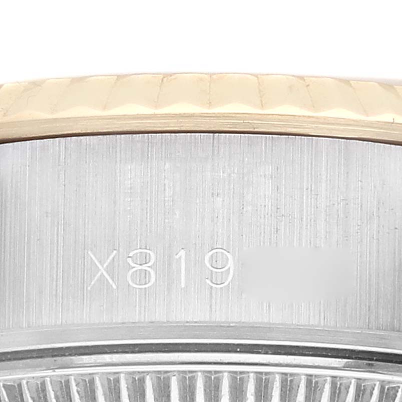 The image shows a close-up angle of the Rolex Datejust 69173G Women's Steel and Gold (two tone) Champagne Dial 69173G Women's Steel and Gold (two tone) Champagne Dial model, highlighting part of the bezel and the engraved serial number.