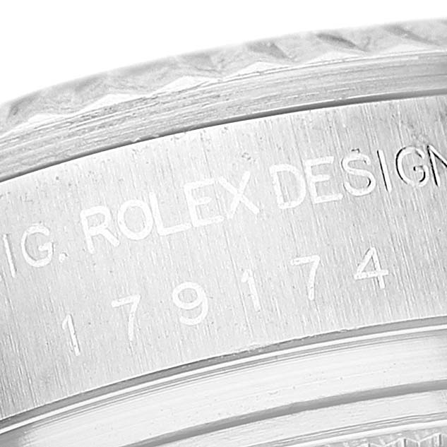 This close-up shows the engraved serial number and "ROLEX DESIGN" inscription on the bezel of a Rolex Datejust 179174 Women's Stainless Steel Pink Dial 179174 Women's Stainless Steel Pink Dial watch.