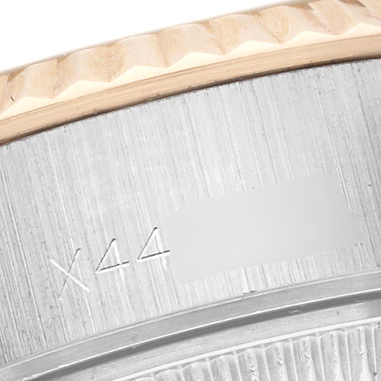 The image shows a close-up of the Rolex Datejust 69173 Women's Steel and Gold (two tone) Champagne Dial 69173 Women's Steel and Gold (two tone) Champagne Dial's fluted bezel and part of the watch case side with engraved details.