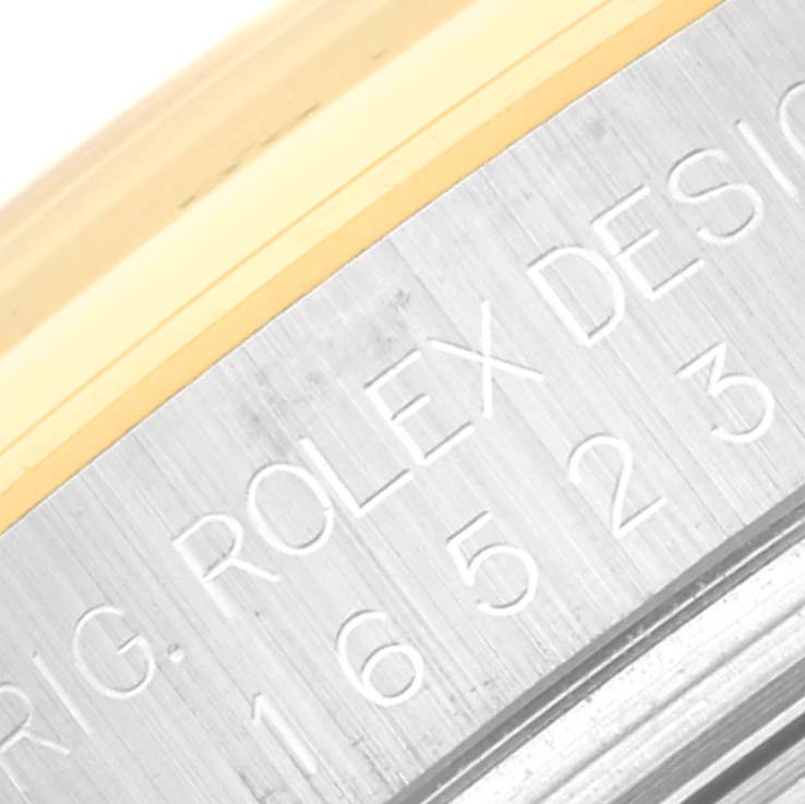 The image shows a close-up of the engraved text and part of the bezel on a Rolex Daytona 16523 Men's Steel and Gold (two tone) Champagne Dial 16523 Men's Steel and Gold (two tone) Champagne Dial watch.