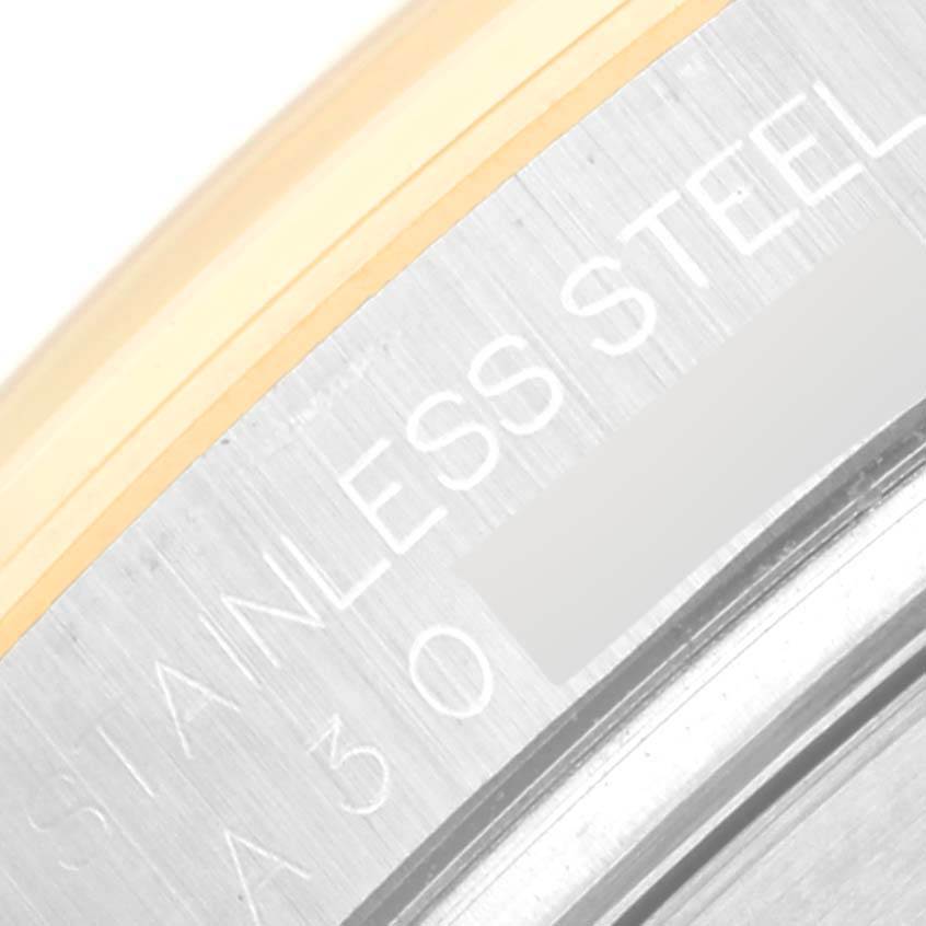 This image shows a close-up of the side case and bezel of a Rolex Daytona 16523 Men's Steel and Gold (two tone) Champagne Dial 16523 Men's Steel and Gold (two tone) Champagne Dial, highlighting the "STAINLESS STEEL" engraving.