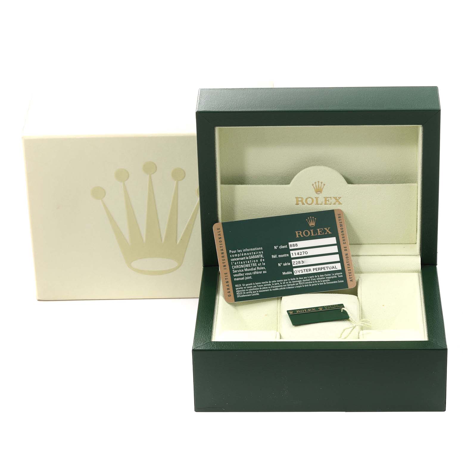 This view shows the packaging of a Rolex Explorer 114270 Men
s Stainless Steel Black Dial 114270 Men
s Stainless Steel Black Dial, including the watch box, warranty card, and a green tag.