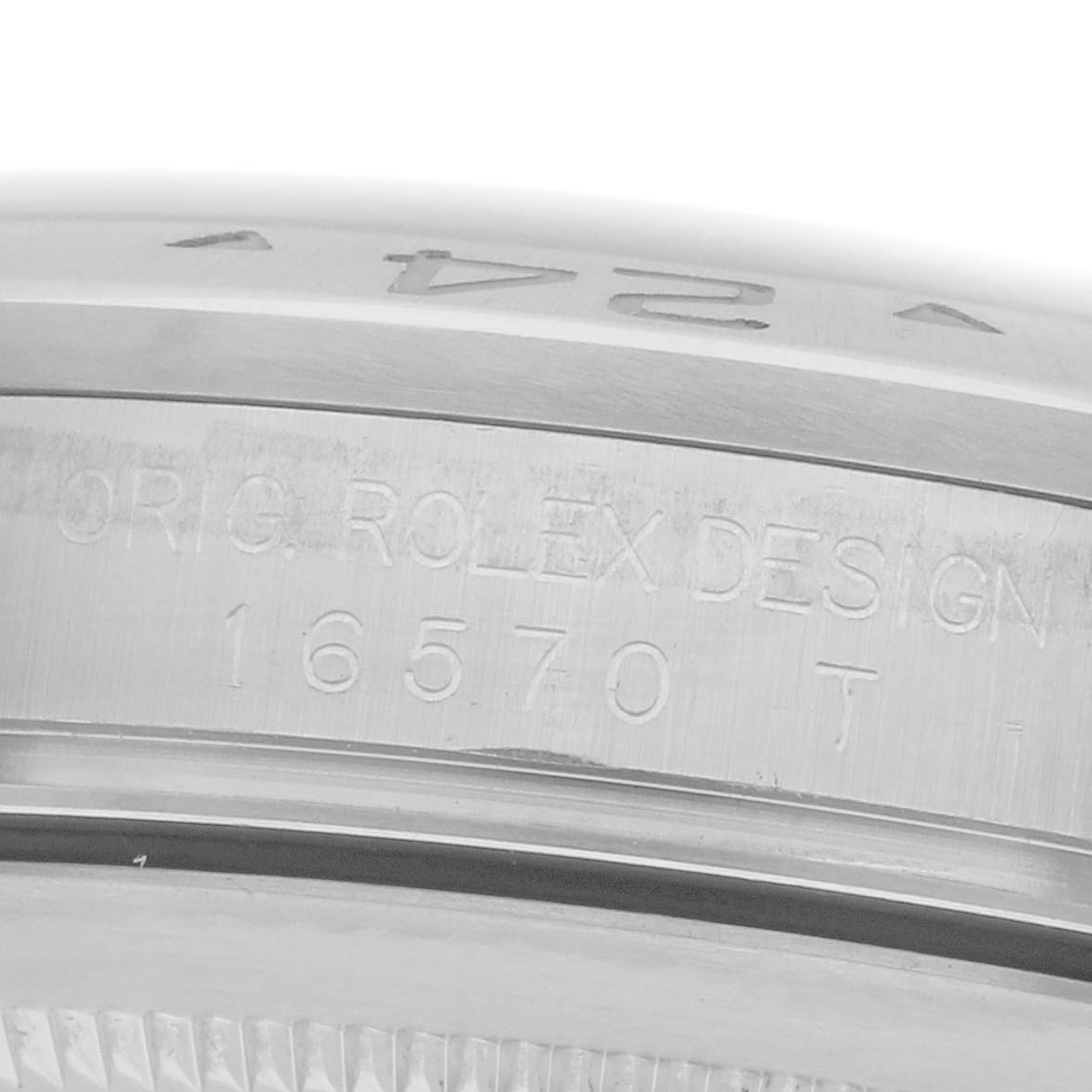 The image shows a close-up of a Rolex Explorer 16570 Men's Stainless Steel White Dial 16570 Men's Stainless Steel White Dial watch's engraved case side, featuring the model number and "Orig. Rolex Design."
