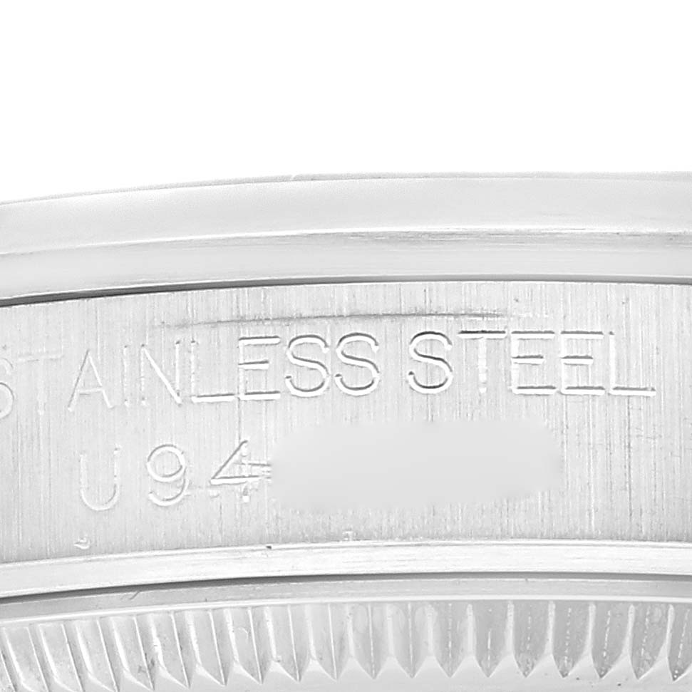 This image shows a close-up view of the case back edge of a Rolex Mid-Size 67480 Women
s Stainless Steel Blue Dial 67480 Women
s Stainless Steel Blue Dial watch, highlighting the stainless steel engraving and part of the serial number.
