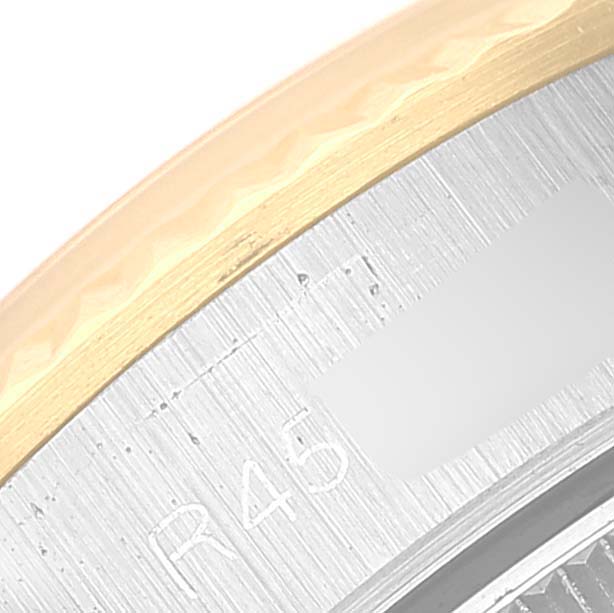The image shows a close-up of the bezel and edge of the case back of a Rolex Oyster Perpetual 67193 Women's Steel and Gold (two tone) Silver Dial 67193 Women's Steel and Gold (two tone) Silver Dial watch.