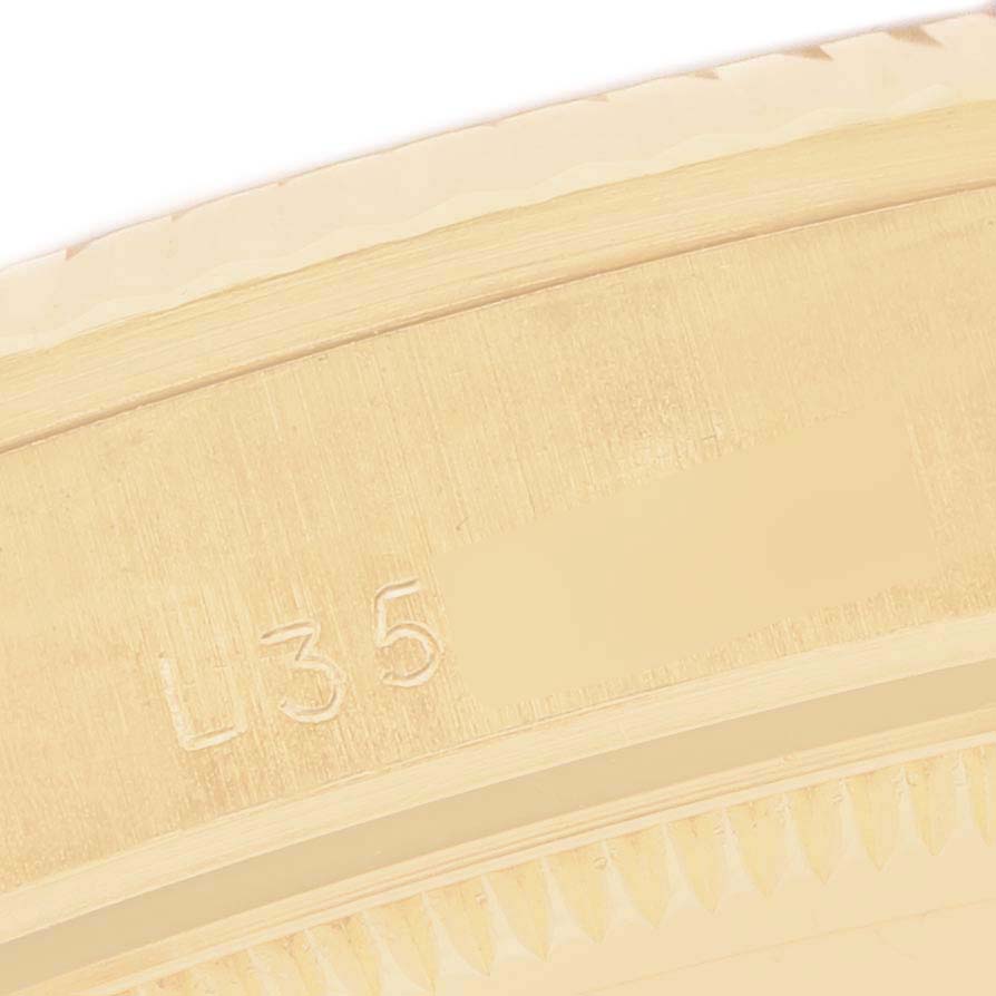 The image shows a close-up of the engraved case edge of a Rolex President 68278 Women's Yellow Gold Blue Dial watch.