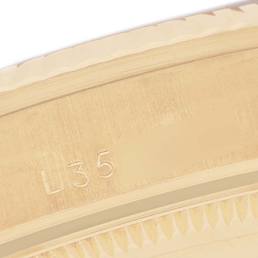 The image shows a close-up of the case edge of the Rolex President 68278 Women's Yellow Gold Blue Dial model, highlighting the engraving and fluted bezel.