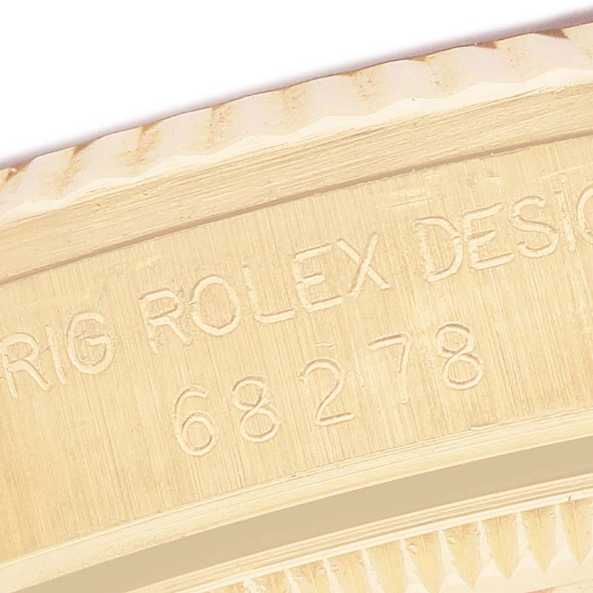 The image shows an engraved side of a Rolex President 68278 Women's Yellow Gold Blue Dial watch with part of the bezel visible.