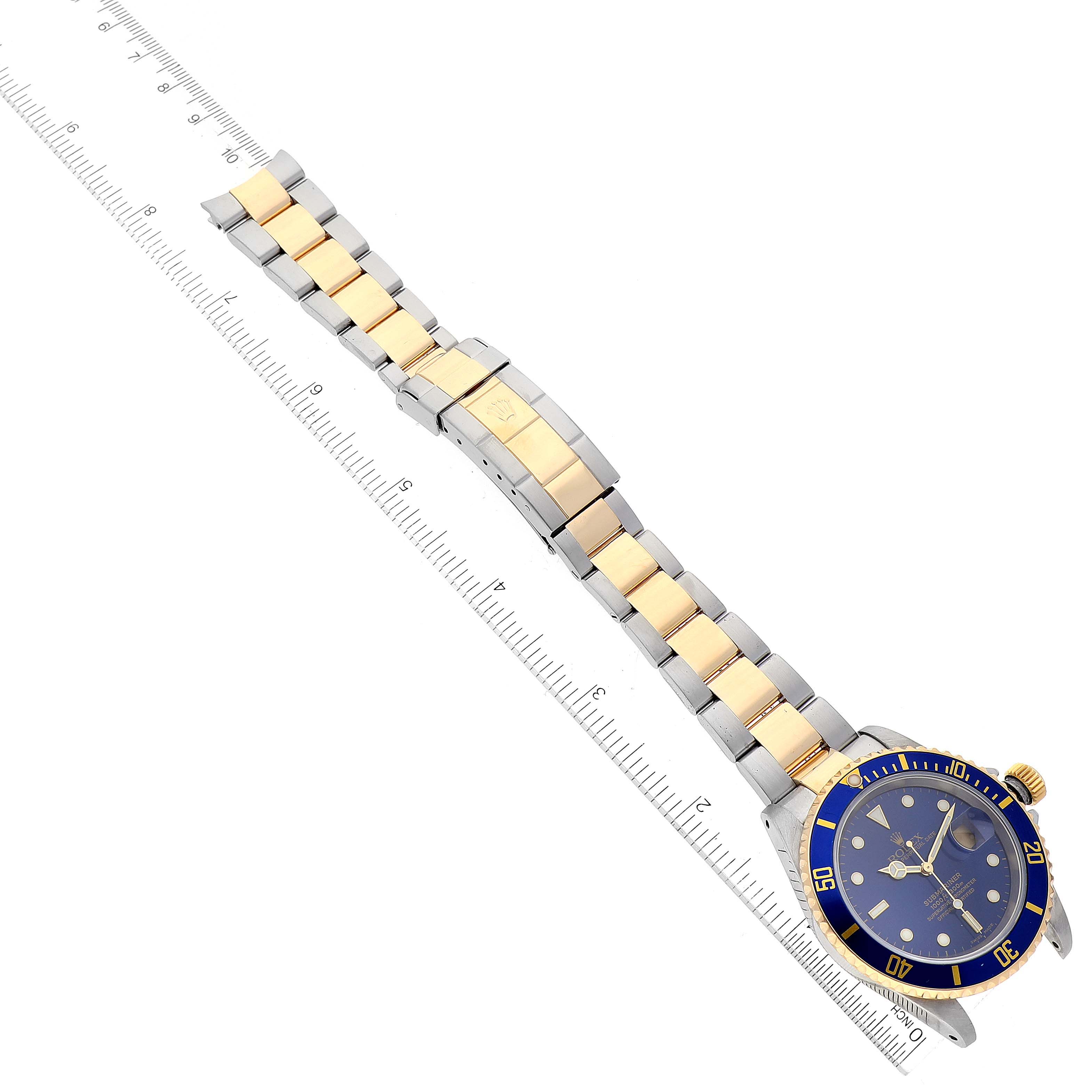 The image shows a Rolex Submariner 16613 Men's Steel and Gold (two tone) Blue Dial 16613 Men's Steel and Gold (two tone) Blue Dial watch from an overhead angle, displaying its blue dial, bezel, and two-tone bracelet.