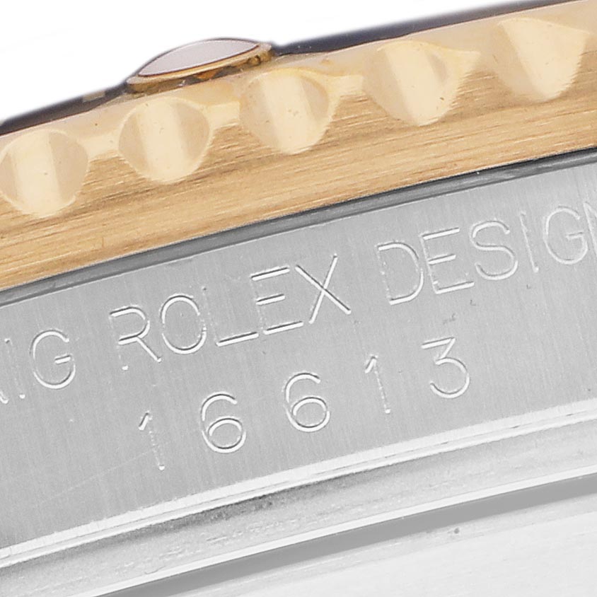 The image shows a close-up of the Rolex Submariner 16613 Men's Steel and Gold (two tone) Black Dial 16613 Men's Steel and Gold (two tone) Black Dial model's bezel and case edge, highlighting the engraved model number.